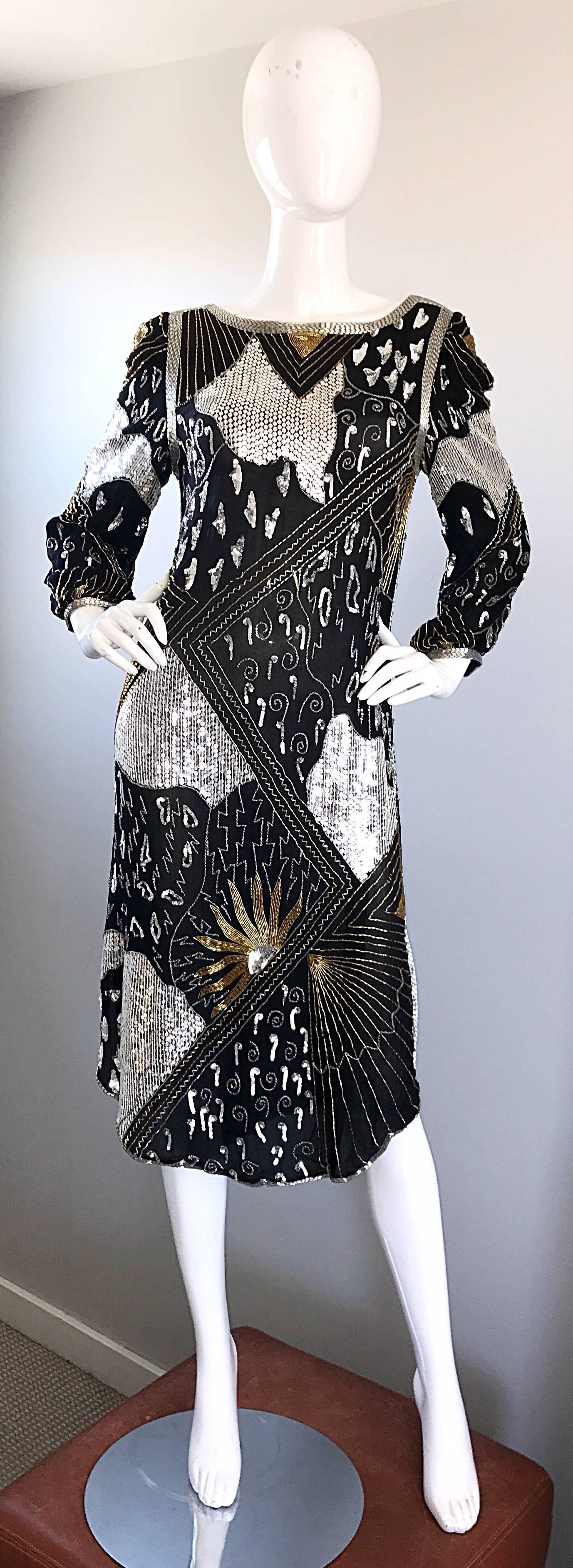 Spectacular vintage JUDITH ANN black silk chiffon long sleeve Gatsby flapper style dress! Features thousands of hand-sewn silver and gold sequins and beads throughout. Beaded sleeve cuffs feature hidden snaps. Side vent at each side of the leg.