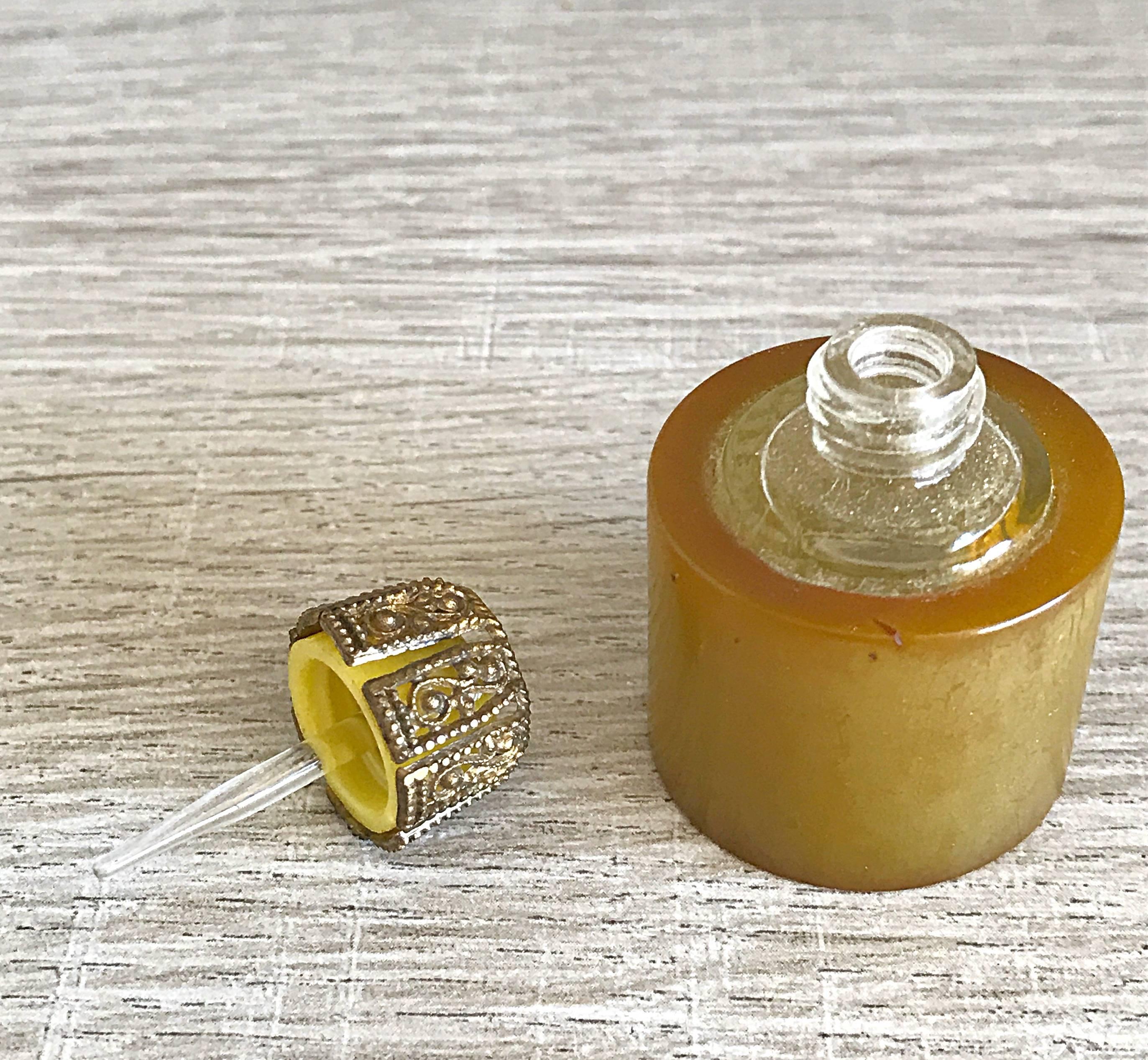 Rare vintage 30s Bakelite butterscotch / amber colored perfume holder and dauber! Perfect travel size that easily fits in any purse / hand bag. Screw caps shuts securely, and features a dauber to brush across the wrists and neck. Decorative gold /