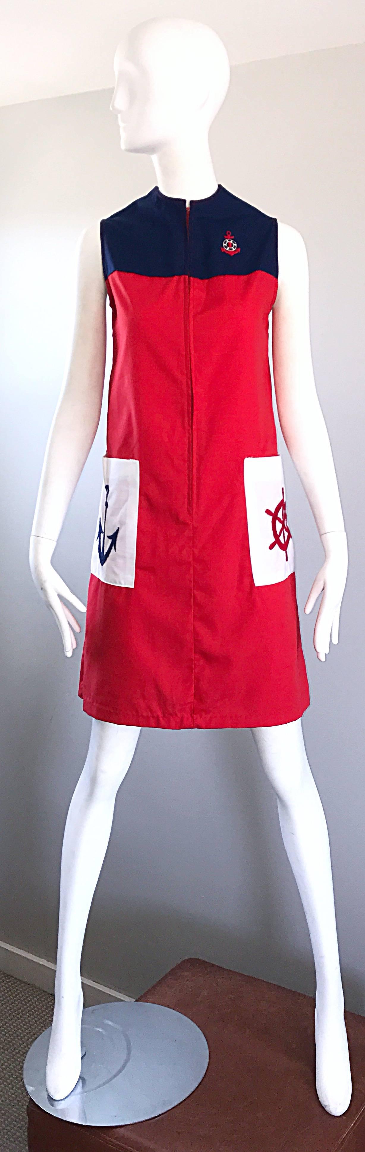 Chic 1960s red, white and blue nautical A-Line cotton blend sailor dress! Features a color block body with embroidery at each hip pocket and on the left breast. Anchor embroidered at right hip pocket, and ship wheel embroidered on left hip pocket.