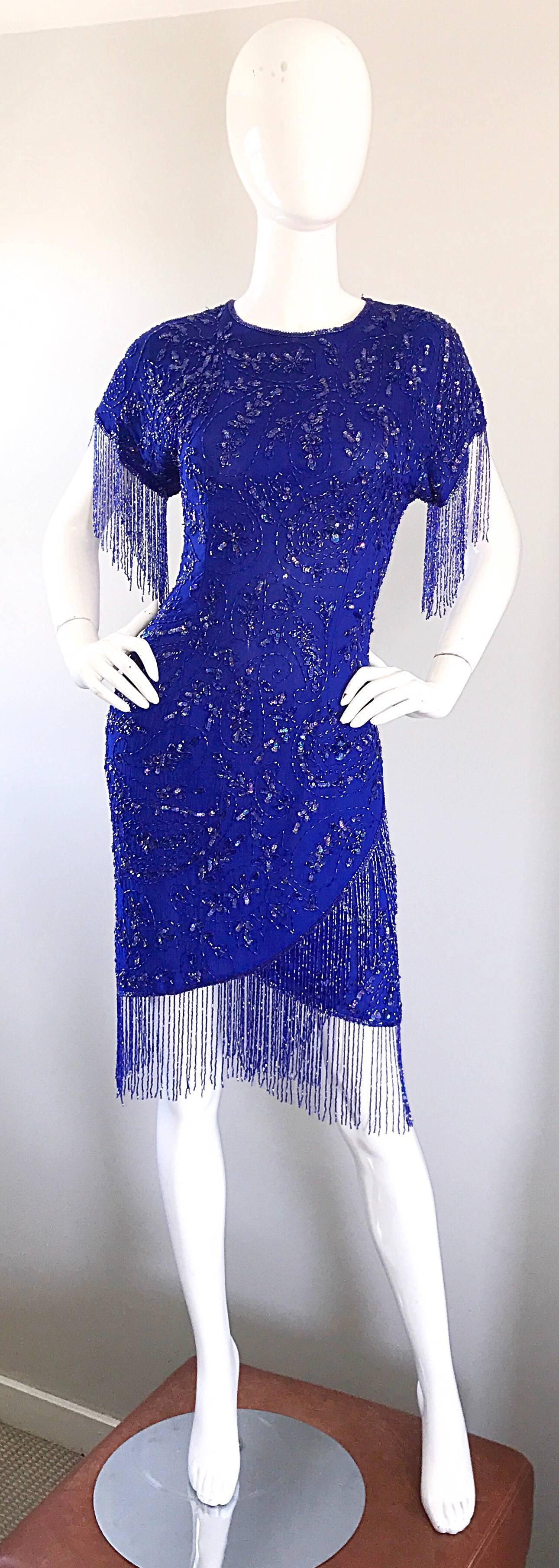 Incredible 90s royal blue silk fully beaded and sequined fringed flapper style short sleeve dress! Features thousands of hand sewn sequins and beads throughout the entire dress. Beaded fringe trim at each sleeve and at the hem. 100% Silk. Hidden