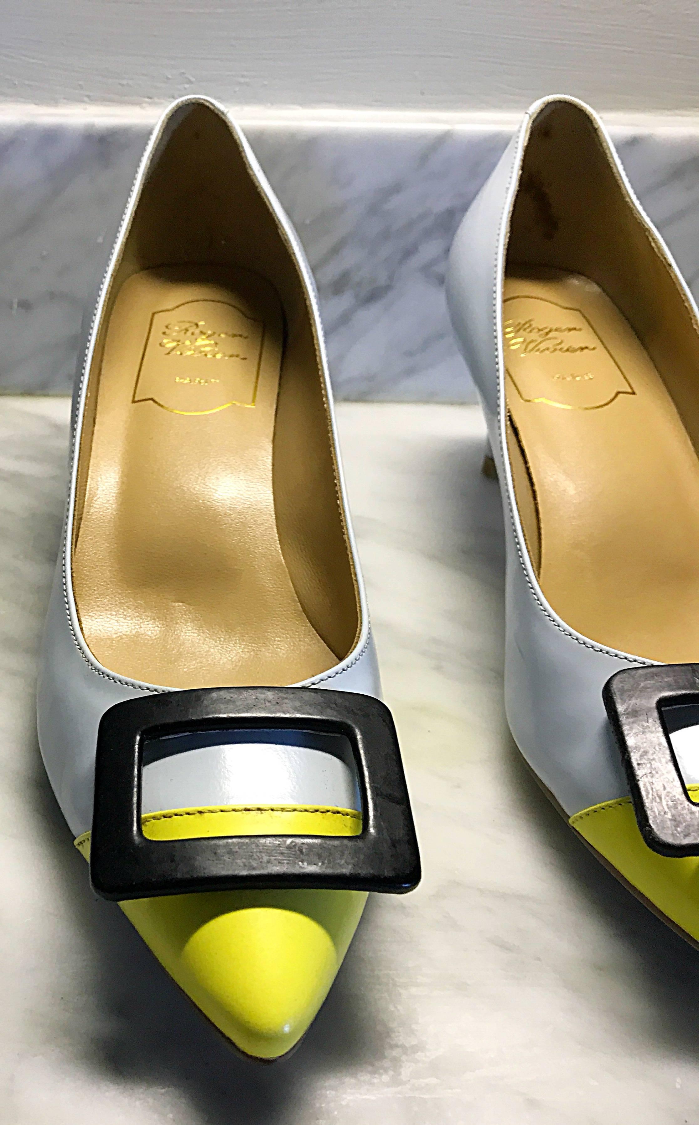 Chic and classic ROGER VIVIER baby blue and yellow color lock leather heels! Features a sensible and comfortable low heel, that is just shy of a kitten heel. Signature Vivier oversized black buckle at toe. Leather sole with rubber support. Can
