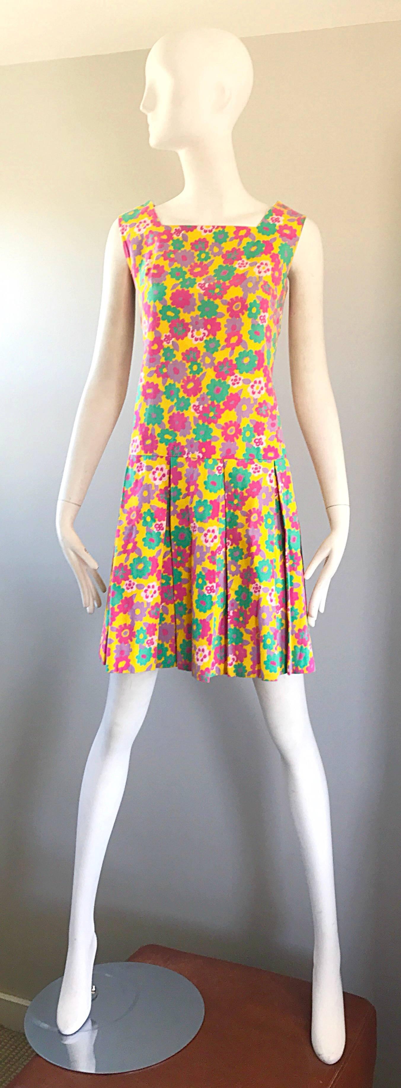 Super chic vintage yellow, green, pink, purple and white daisy flower print cotton skooter dres! Features a nice tailored bodice with a pleated flattering 
A-Line skirt. Hidden metal zipper up the back with hook-and-eye closure. Great with flats,