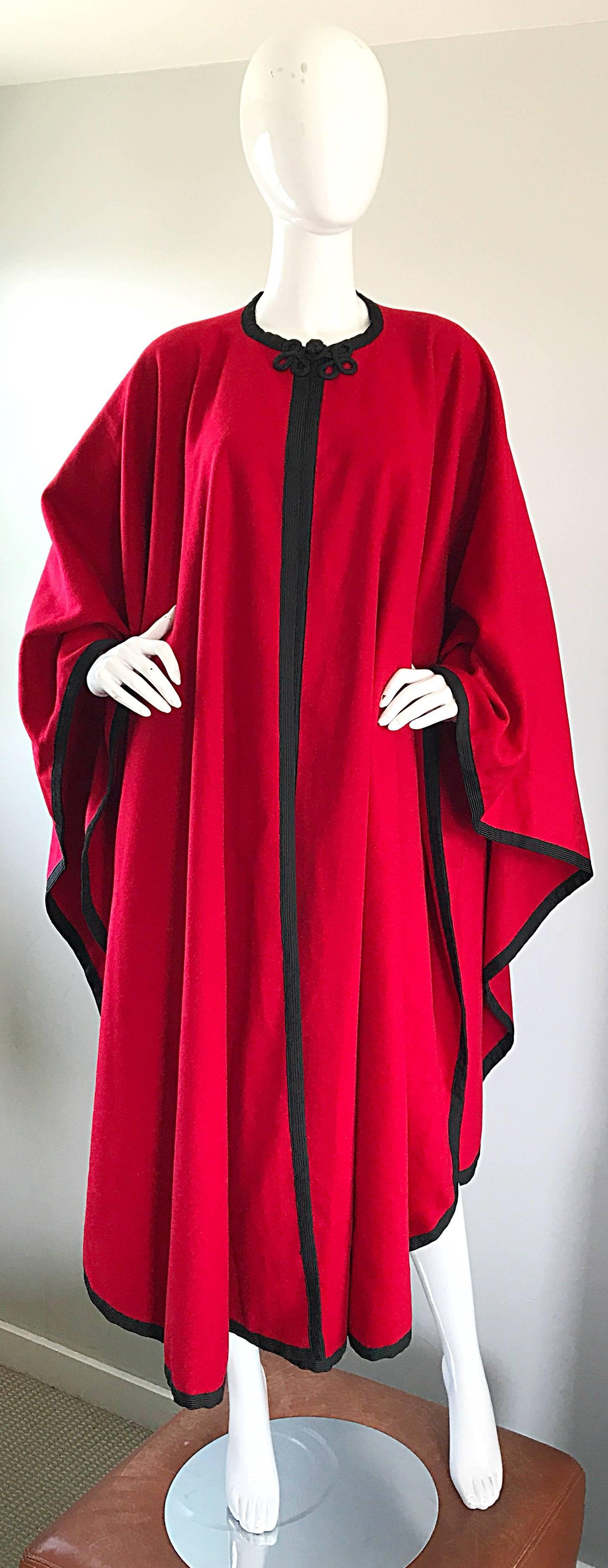 Amazing and rare 70s YSL red and black heavy wool cape! This musuem worthy piece is from Saint Laurent's most famed 1976 Russian Collection! Features black embroidered trim, with an embroidered closure at top center neck. Dramatic folds wear nicely