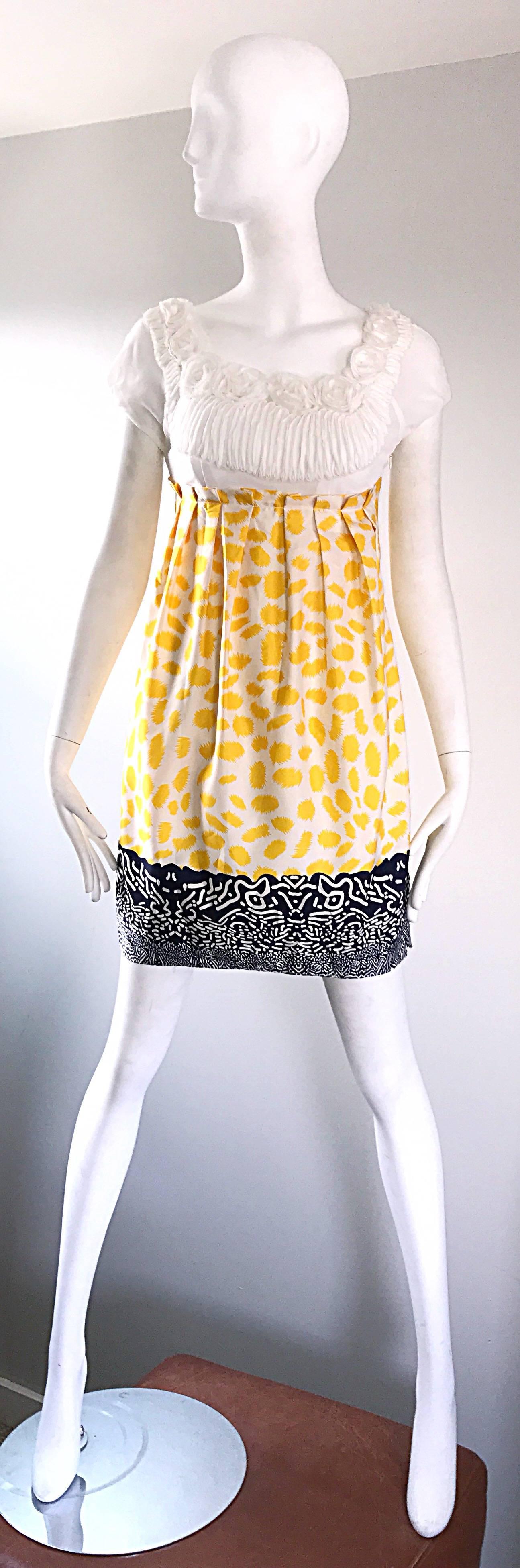 New MARC JACOBS Collection empire waist silk babydoll puff sleeve dress! Features vibrant yellow, navy blue and white abstract print. Pleated ruffle detail at waist. Angelic white chiffon bodice, with flower appliqués along the neck. Hidden zipper