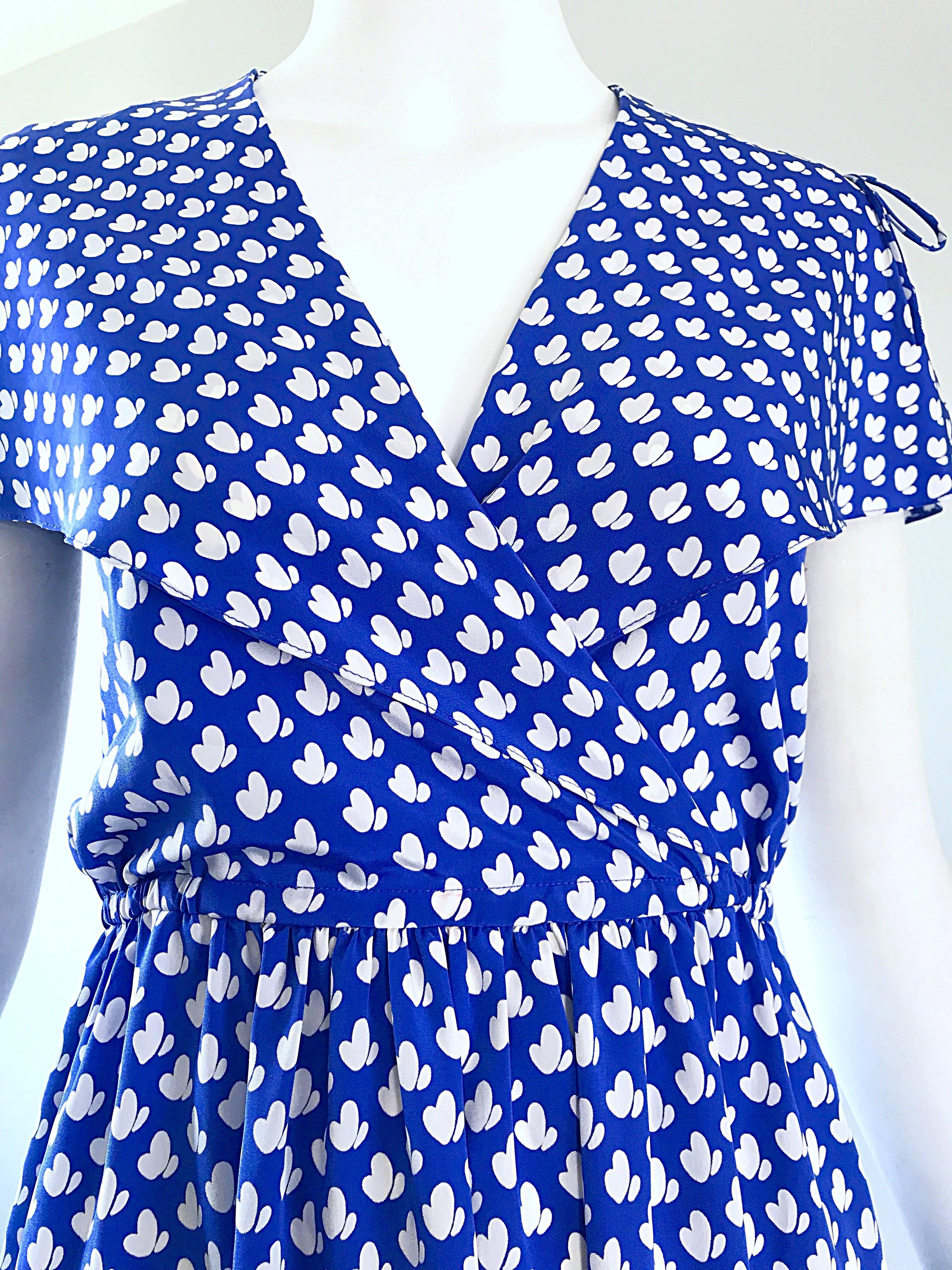 Flirty late 1970s PIERRE CARDIN for NEIMAN MARCUS royal blue and white heart print flutter sleeve dress! Features a blue background with white hearts printed throughout. Elastic waistband stretches to fit, with pockets at each side of the hips.