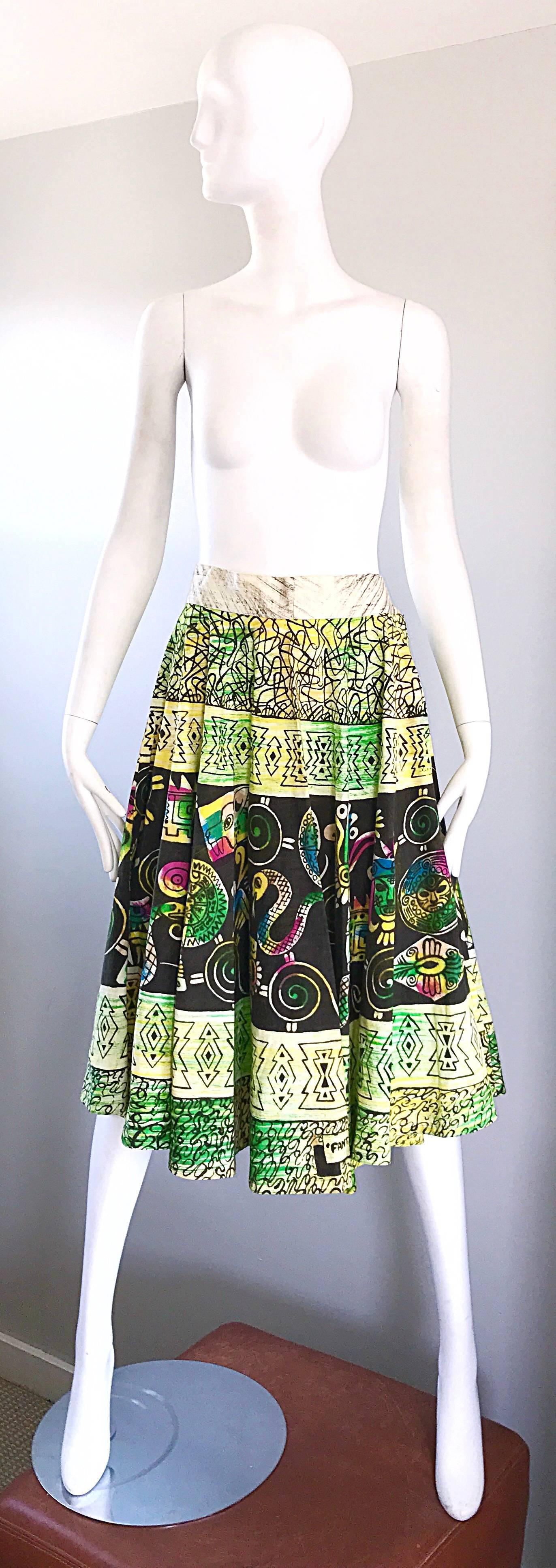 Amazing and very rare 1950s hand painted Mexiacan cotton skirt! Features Aztec/Myan handpainted characters throughout. Vibrant colors of green, pink, blue, yellow and black. Full metal zipper up the side with hook-and-eye closure. Can easily be