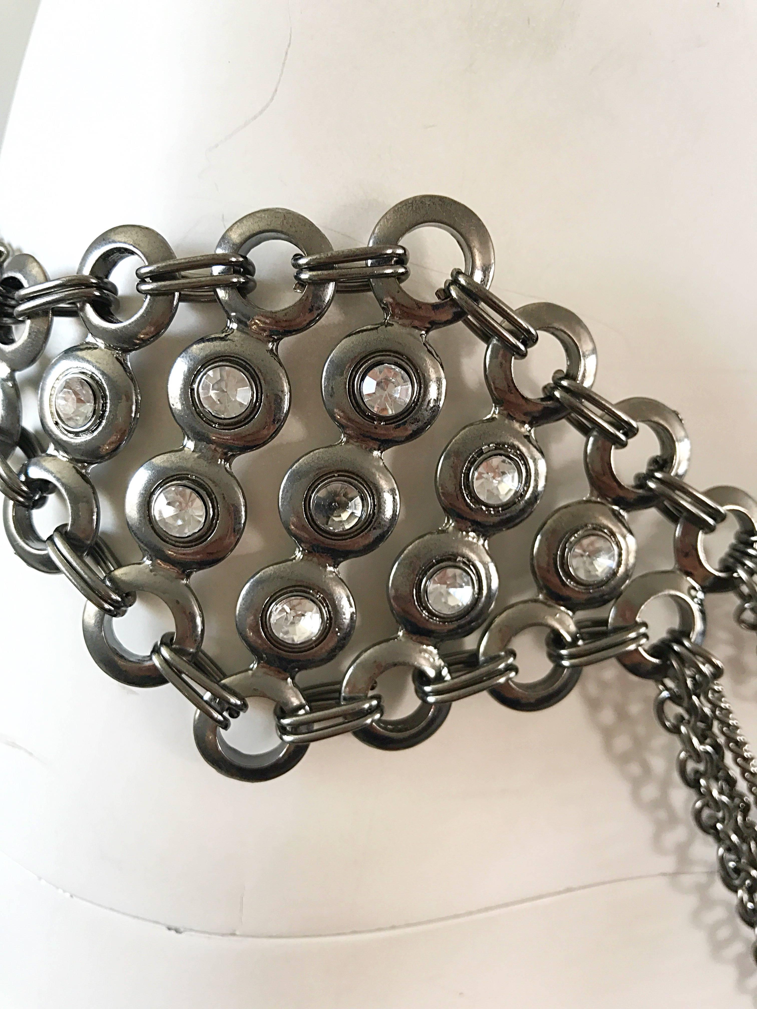 Amazing 1970s silver and gunmetal rhinestone multi-strand asymmetrical belt! Features a large crystal rhinestone pendant at the right side of the waist. Clasp closure. The perfect way to quickly jazz up a little black dress. Could also be used as a