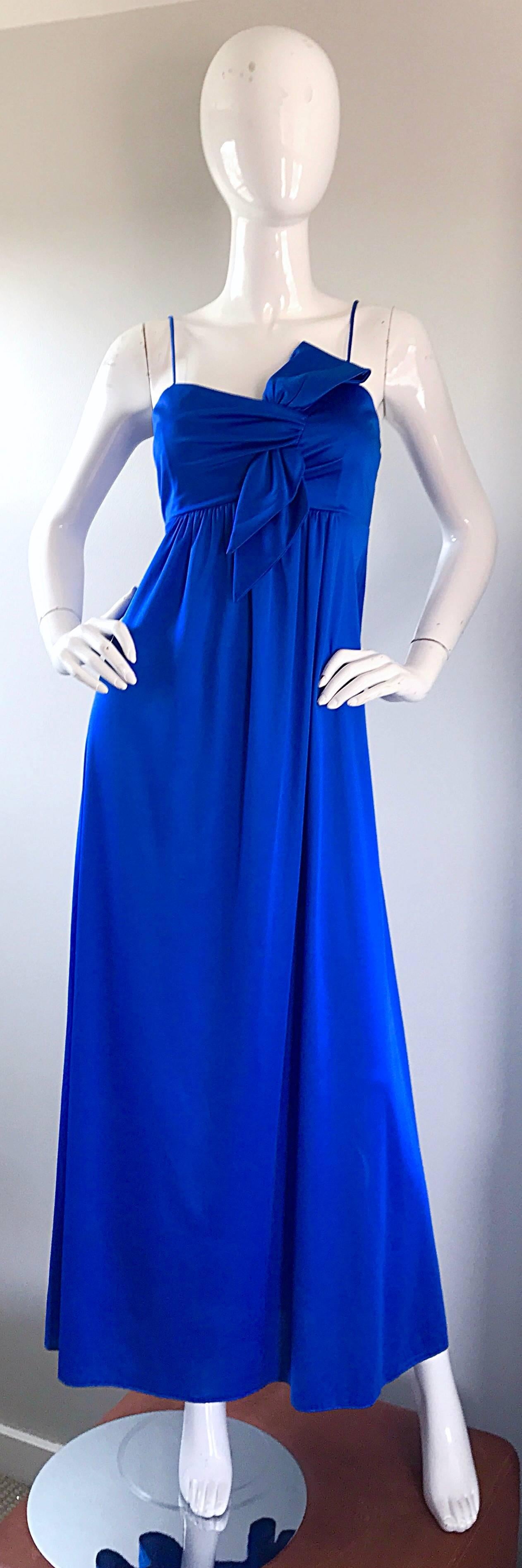 Gorgeous 1970s royal blue slinky jersey maxi dress! Vibrant bold blue color matches practically any accessory. Origami-like angular bow detail at left breast. Hidden zipper up th eback with hook-and-eye closure. Very well made, with lots of stretch