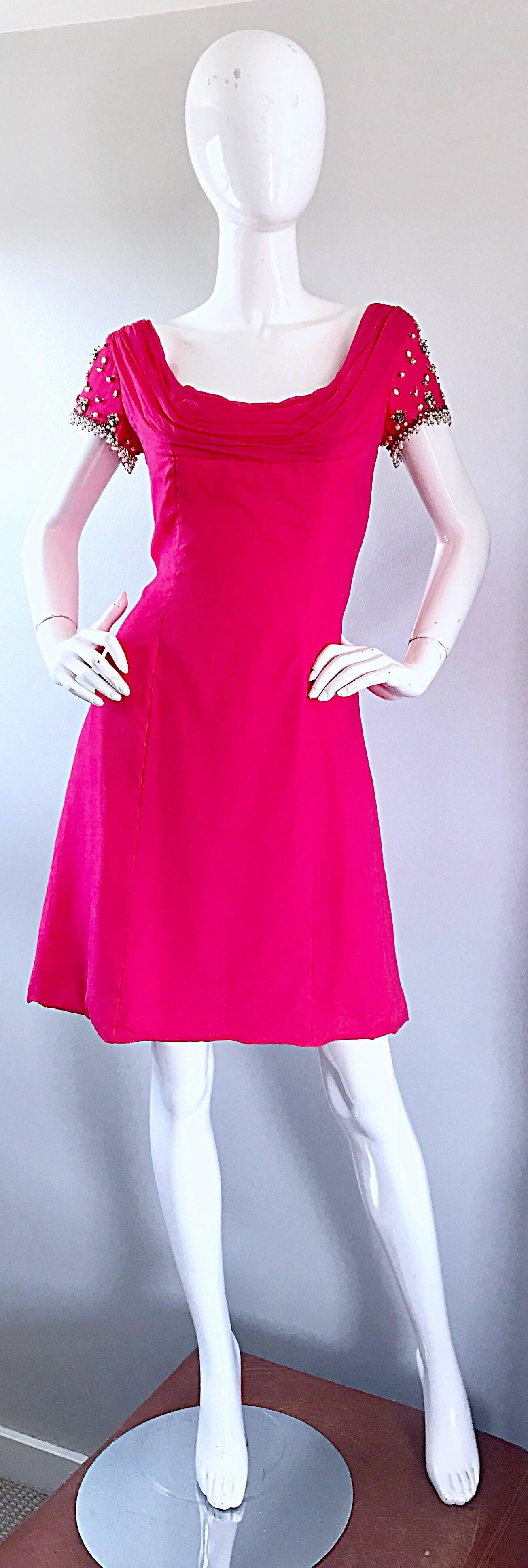 Beautiful early 1960s LILLI DIAMOND hot pink chiffon A-Line dress! Brand new with original store tags! Features hand-sewn beads, rhinestones and pearls on each sleeve. Full metal zipper up the back with hook-and-eye closure. Fitted bodice, with a