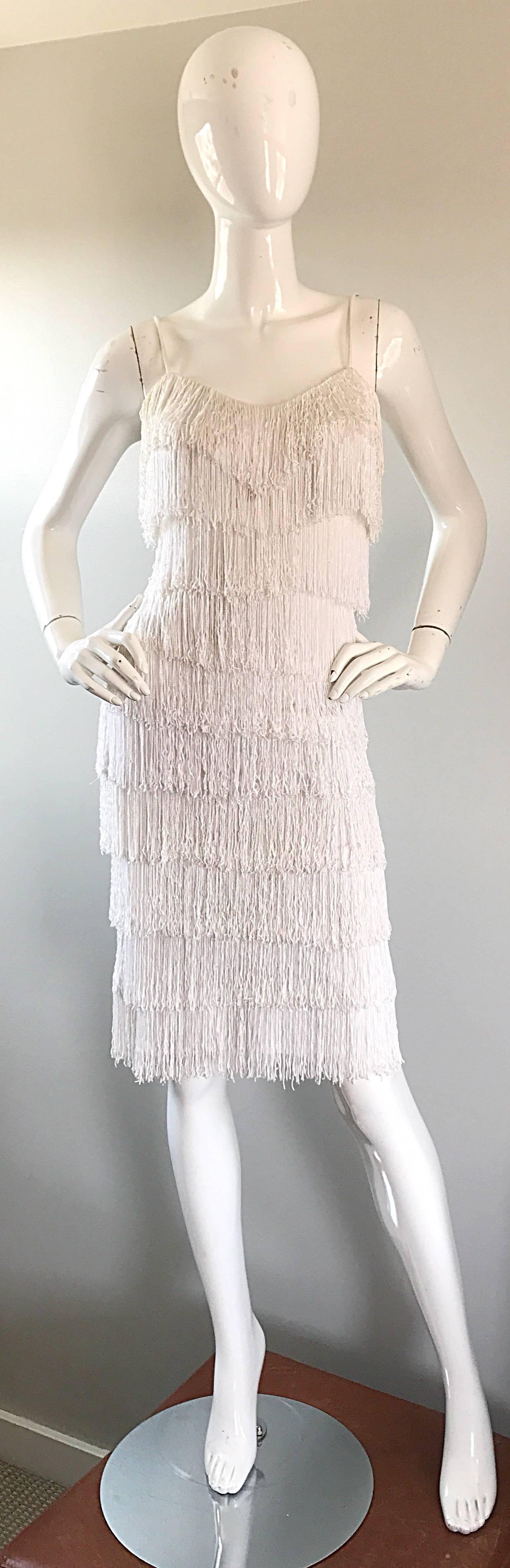 Incredible vintage 70s does 20s fully fringed white jersey dress! Features panels of hand-sewn fringe throughout the entire dress....looks AMAZING on the dance floor! Hidden zipper up the back with hook-and-eye closure. The perfect statement dress,
