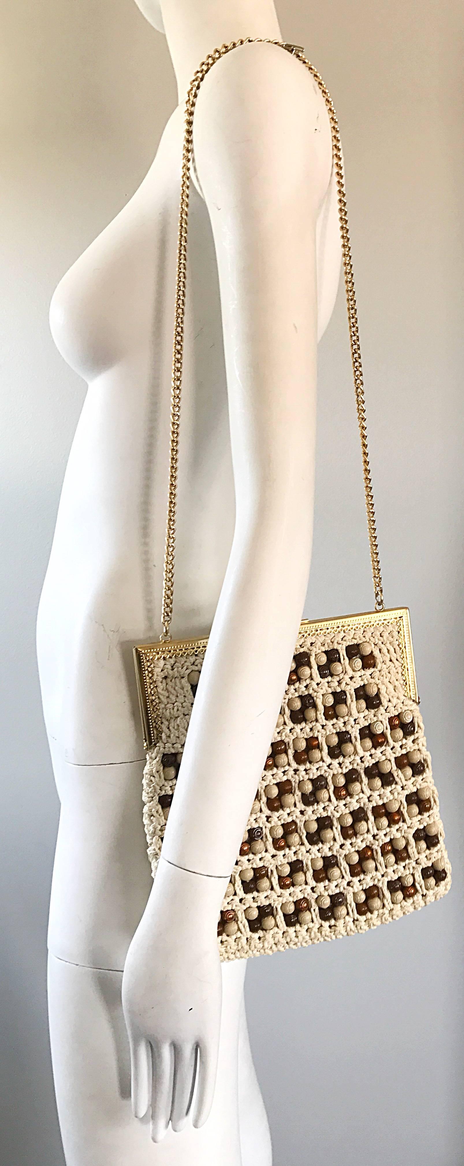 Chic 70s Italian ivory / white and brown hand crochet boho shoulder handbag! Features hundreds of brown wood looking beads on each side. The perfect size to fit all the essentials (smartphone, wallet, makeup, etc. Secure clasp closure. Gold chain
