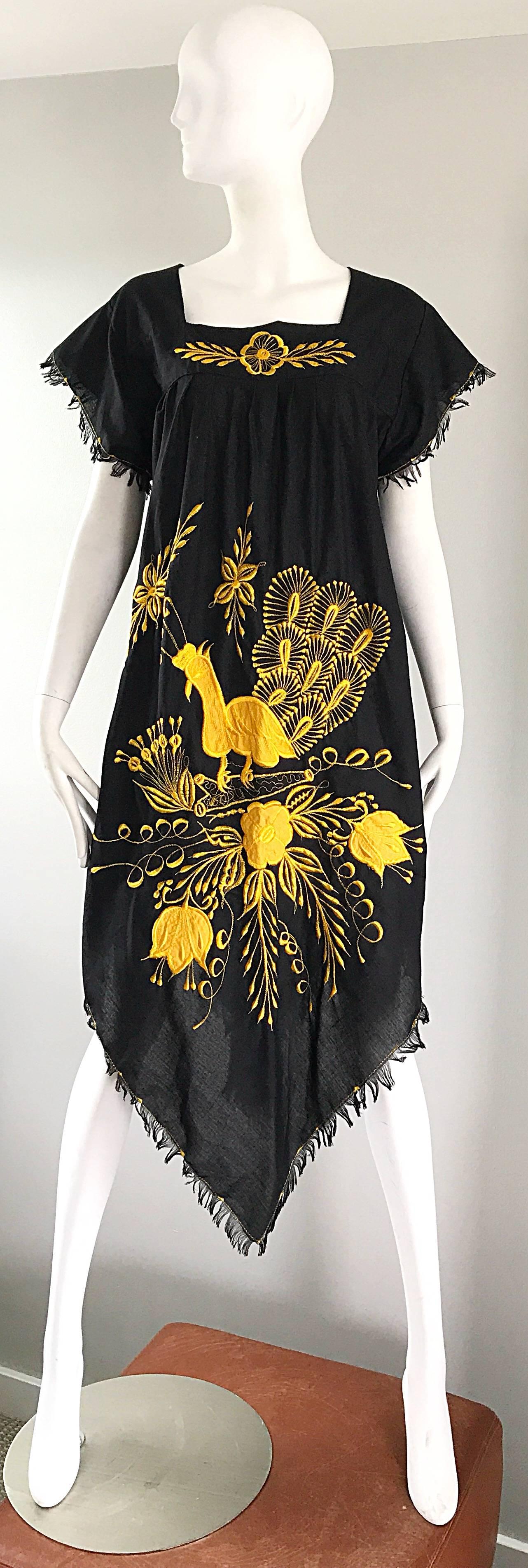 Amazing 70s vintage black and marigold yellow cotton handkerchief hem Mexican kaftan dress. Features yellow embroidery of a peacock and flowers on the front. Frayed edges on the sleeves and the hem. Simply slips over the head. Great over a swimsuit,