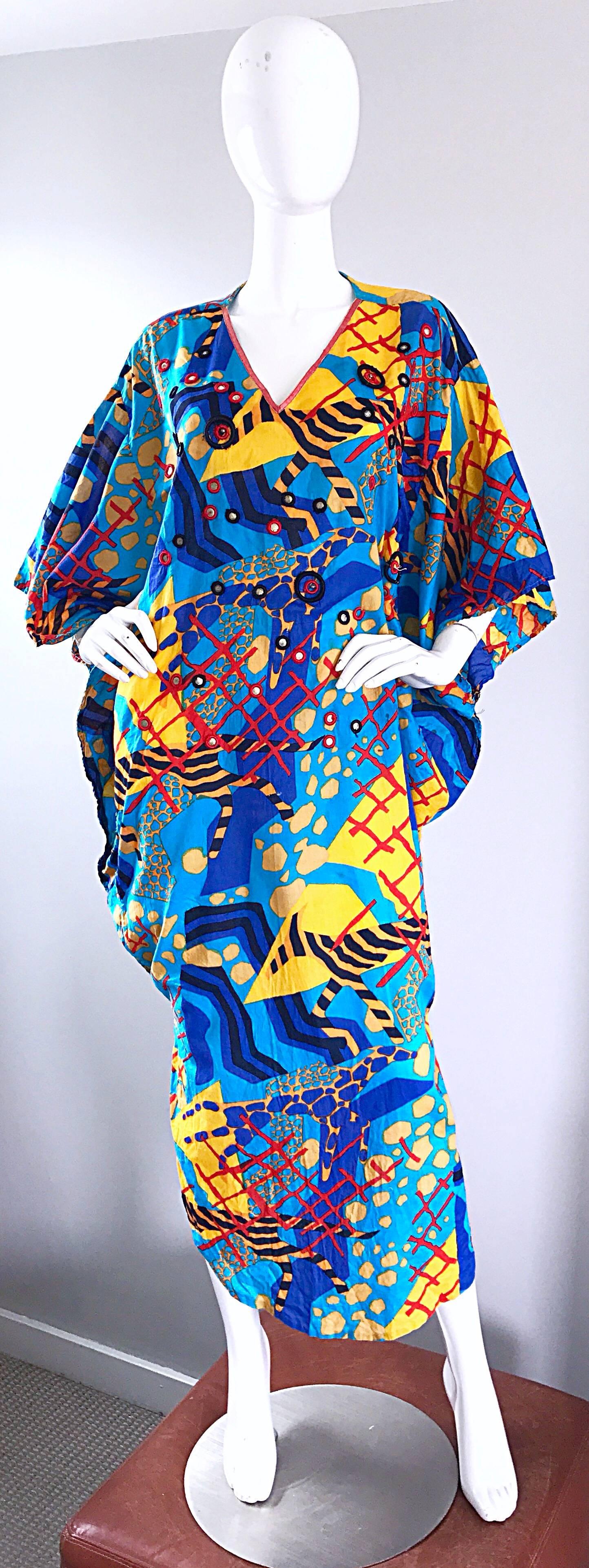 Incredible vintage JUDITH ANN for NEIMAN MARCUS mirror embellished cotton kaftan maxi dress! Features vibrant colors of blue, red, marigold yellow, and black throughout. Mirrored beads hand-sewn throughout. Simply slip this beauty over your head,