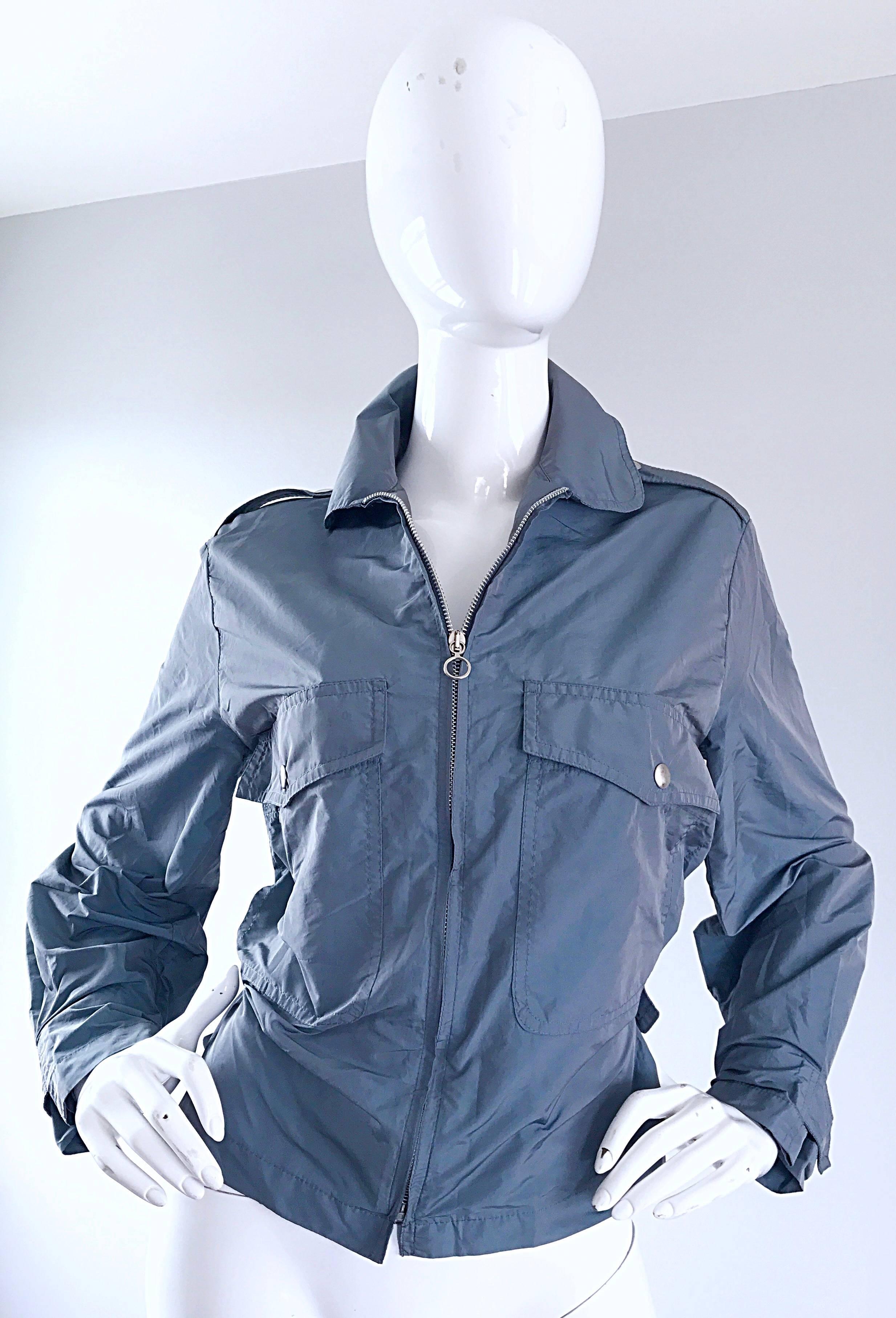 Who says a windbreaker has to be drab?!? This 1990s KRIZIA windbreaker is both chic and functional! Nice steel blue / gray color. Silver zipper up the front, with hidden snaps at each side of the waist to adjust size. Great tailored fit, with