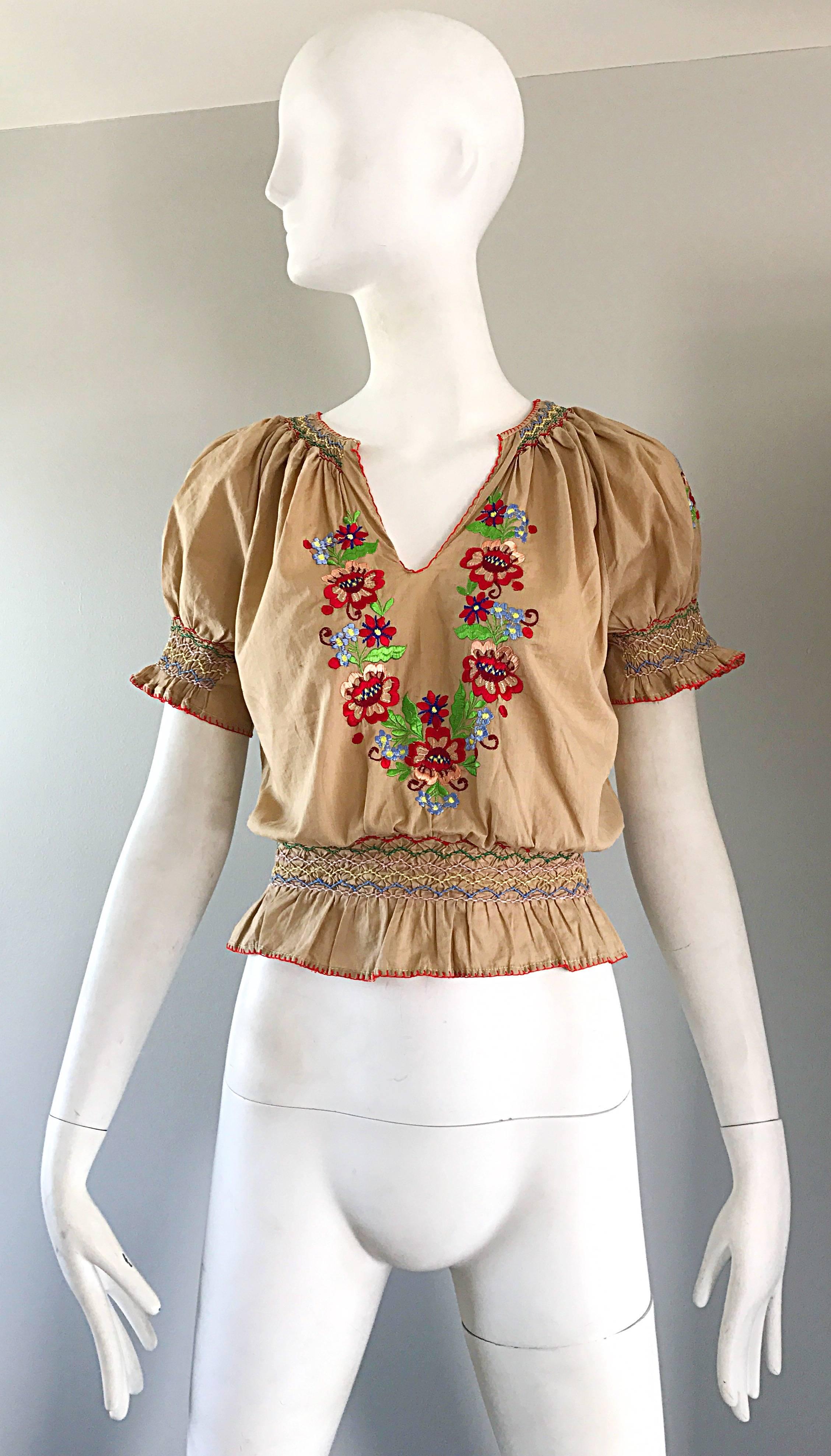 Rare and oh so chic 1940s Hungarian embroidered cotton cropped boho peasant shirt ! Classic light khaki tan color, with hand-sewn embroidered flowers in vibrant red, pink, yellow, green, blue, and white. Smocked detail at sleeve cuffs and at