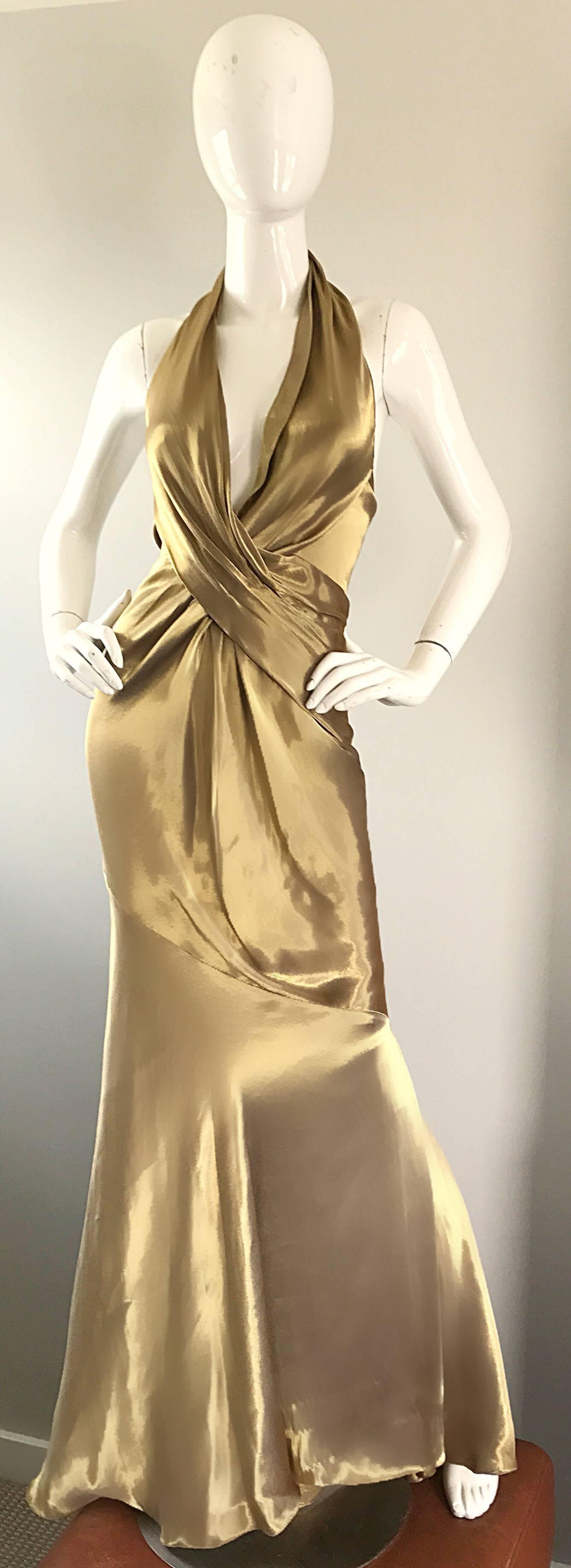 Stunning and sexy 1990s DONNA KARAN black label 'liquid gold' silk halter evening dress. Plunging neckline with an additional built in halter support. Hidden zipper up the side with multiple hook-and-eye closures. Flattering pleated bodice, with a