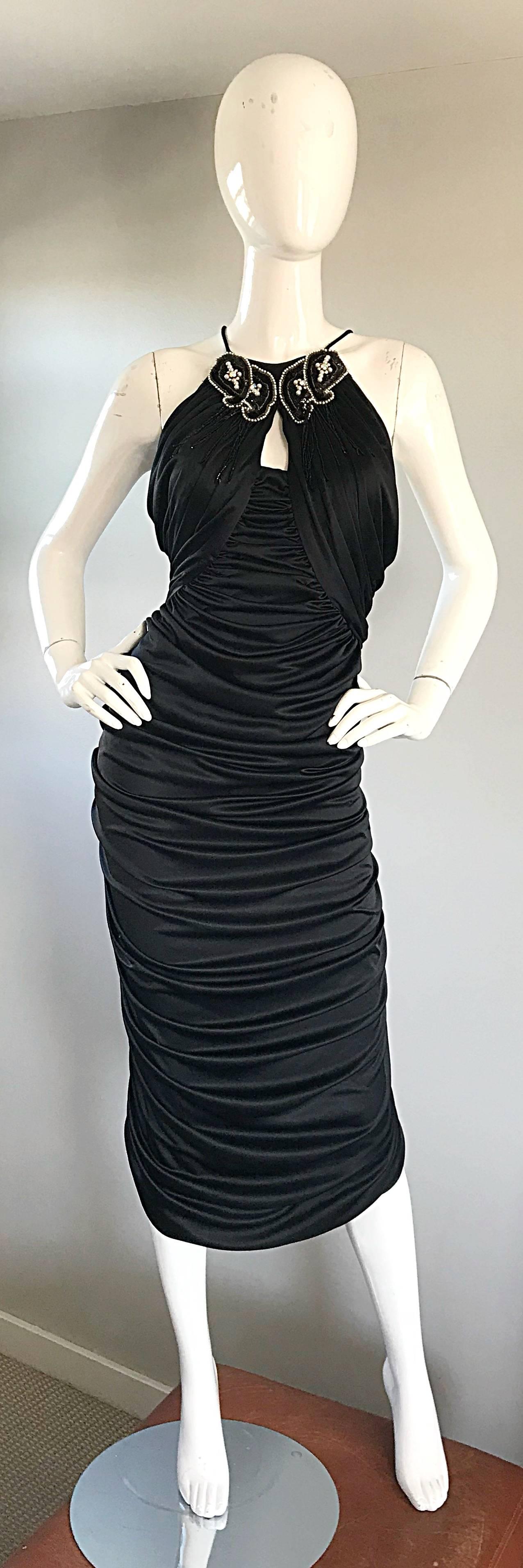 Sexy and super flattering SAMIR black ruched sleeveless cocktail dress! Features a peek-a-boo bust, encrusted with pearls, beads, seed beads and rhinestones. Flattering stretch jersey and ruching stretches to fit. Hidden zipper up the back. 
In