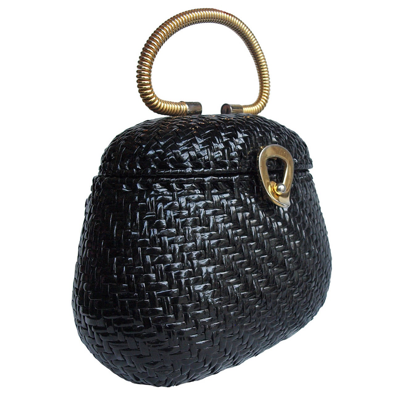 This is an unusual 60's box bag. It is made up of strips of black patent material woven through each other. It has gold metal trimming as well as a gold handle at the top. There is slight fading to the gold of the tear drop clasp, however it is