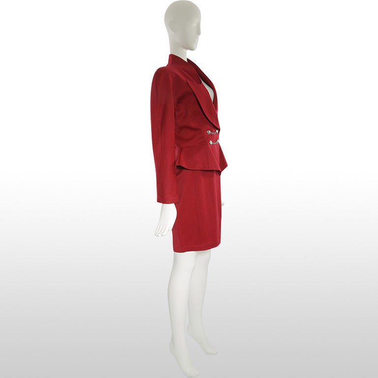 This 1980’s suit by designer Thierry Mugler is made from a beautiful rich burgundy worsted wool fabric. The jacket synchs at the waist and flairs at the bottom to create a peplum shape. The exaggerated peaked lapels are the distinct tailored feature
