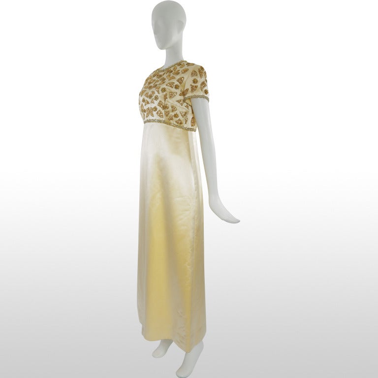 This beautiful 1960's full length gown is by one of The Gathering Goddess's most loved designer brands, Mr Blackwell. It is a made from a luxurious sunshine yellow satin that reflects the light beautifully. The bodice is embellished with gold and