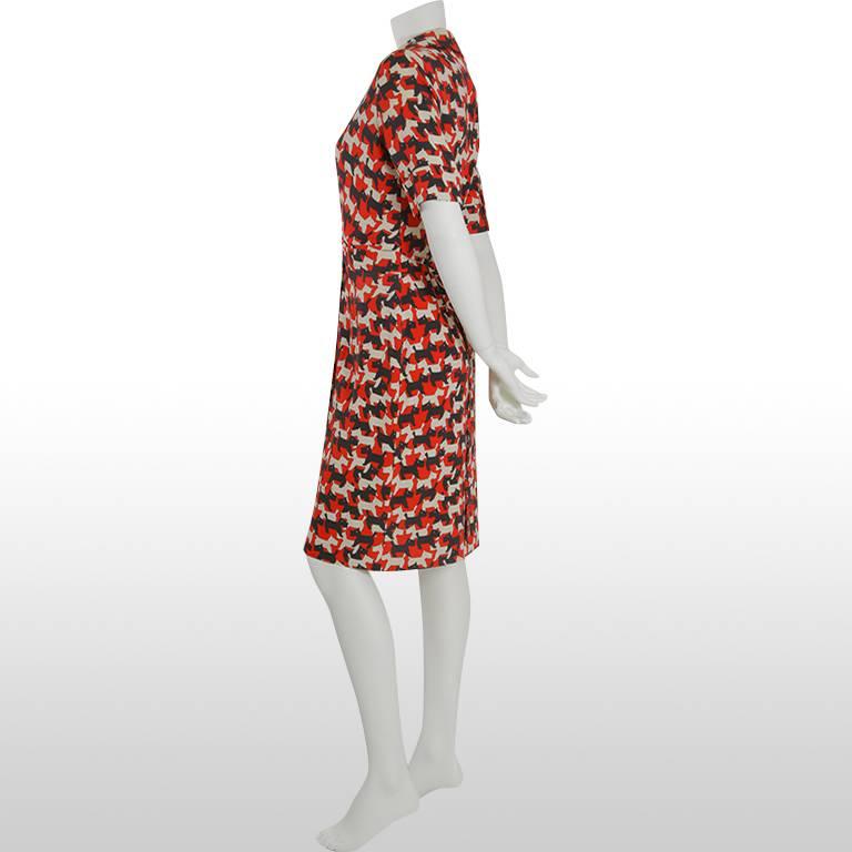This lovely, beautifully cut Cacharel dress is made from a patterned silk and acetate blend depicting white and black Scottie dogs. The dress has a red synthetic lining which may show as you walk. This is an extremely figure flattering shape as the
