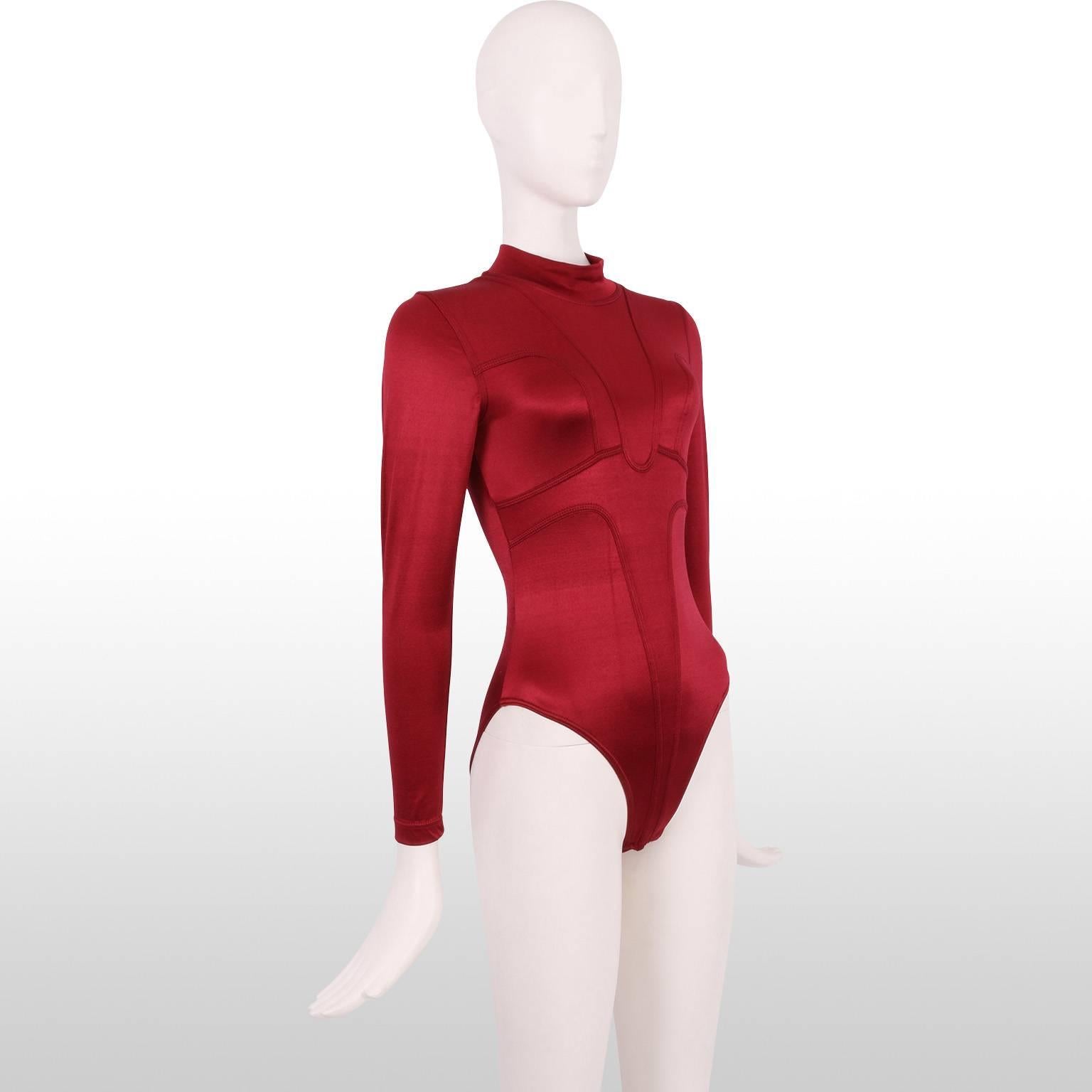 A clubwear classic from the 1980s by Chrissie Walsh. This ruby red body suit has a metallic/satin sheen to it and features Tron-like futuristic detailing and a mock turtleneck. It is in mint condition and ready to be worn. 
Measurements:
Length