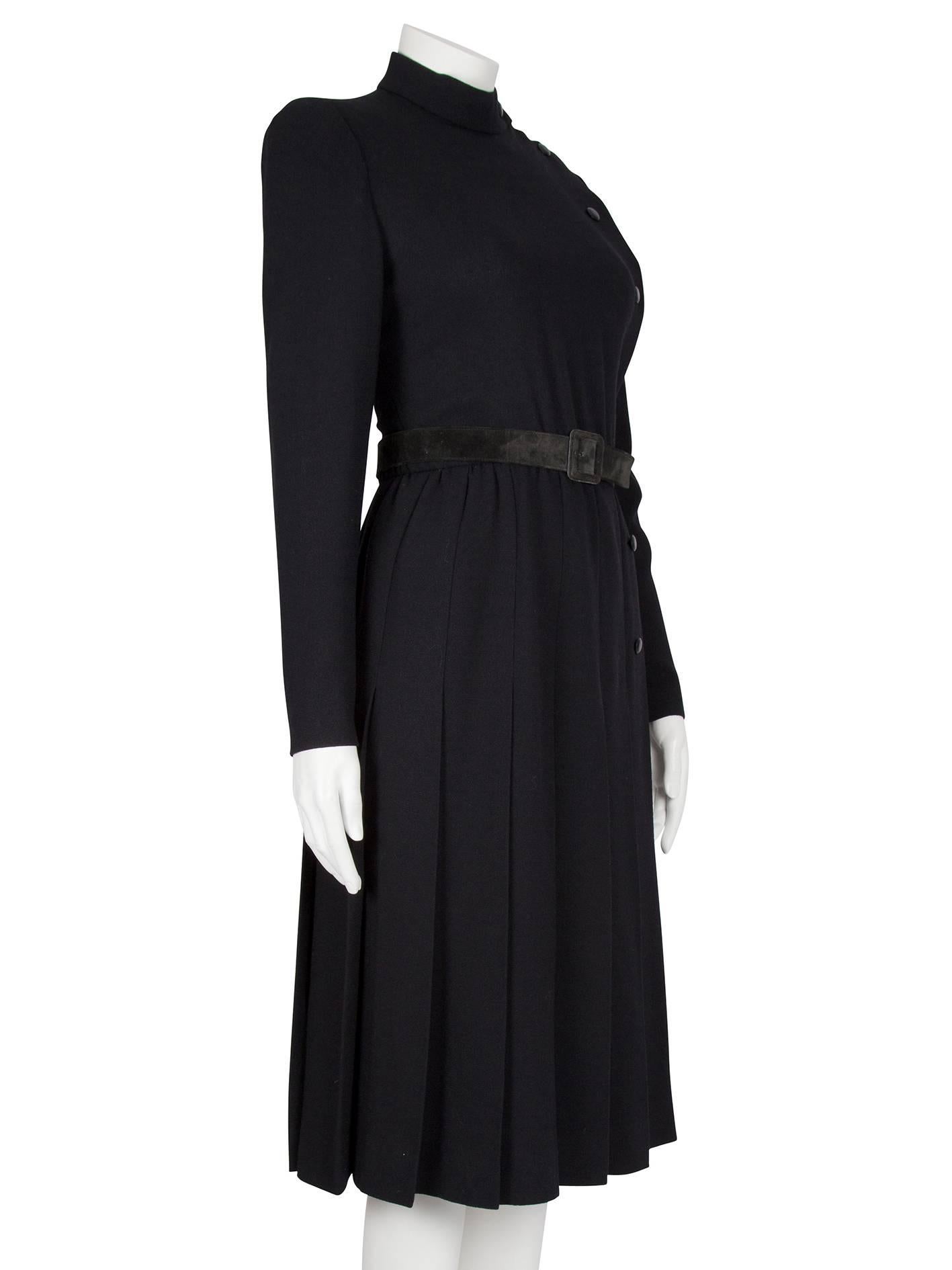 A Dior Couture black silk crepe long-sleeved button-down dress from the Autumn/Winter 1979 collection. The mid-length wrap dress features a pleated skirt and long sleeves with buttoned cuffs and the fabric has a pleasing weight. The dress fastens