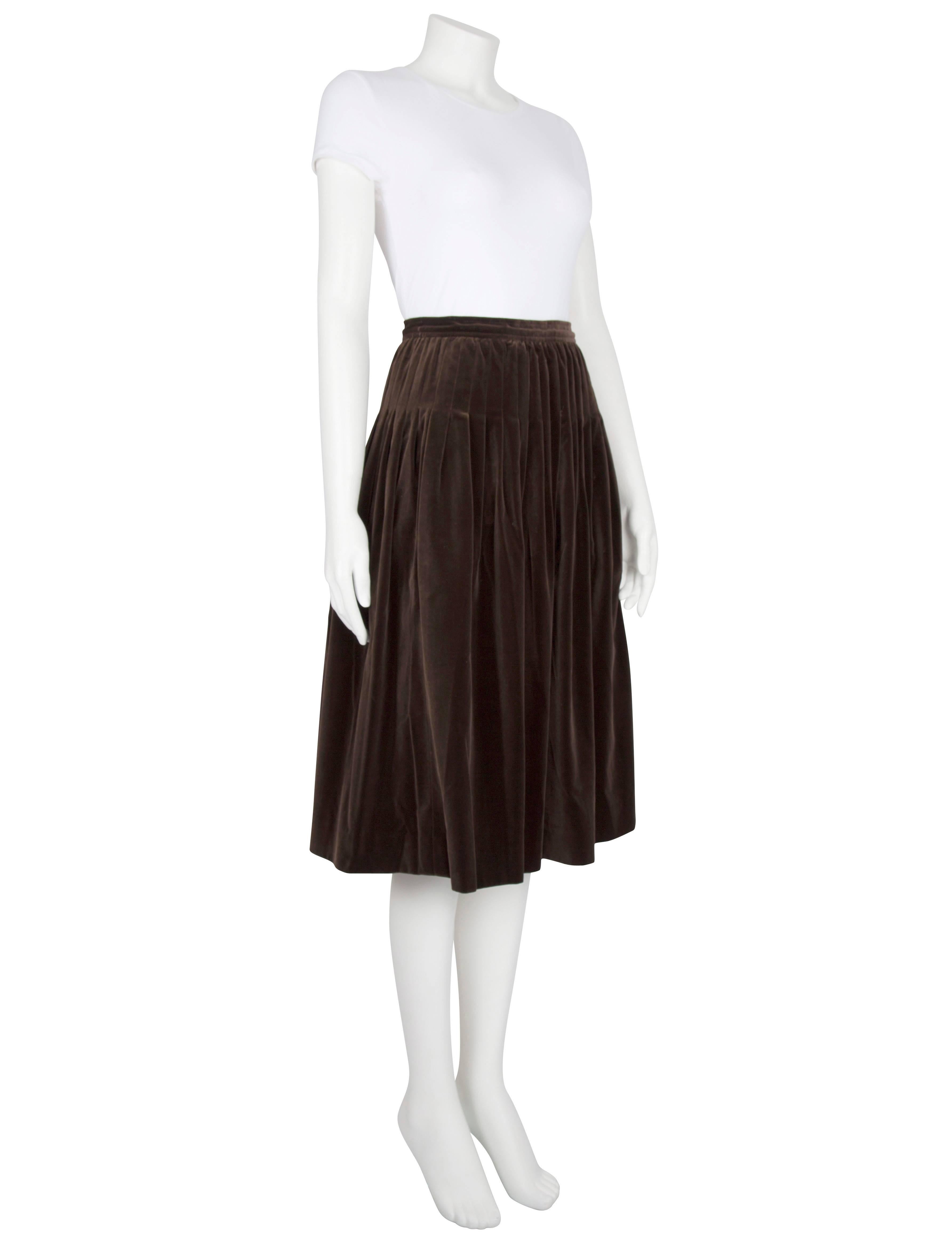 A 1970s Yves Saint Laurent Rive Gauche brown velvet pleated skirt. The soft mid-length skirt features all-over pleats and a brown cotton lining and fastens at the side with a zipper and a hook fastening. Excellent vintage condition; a small and