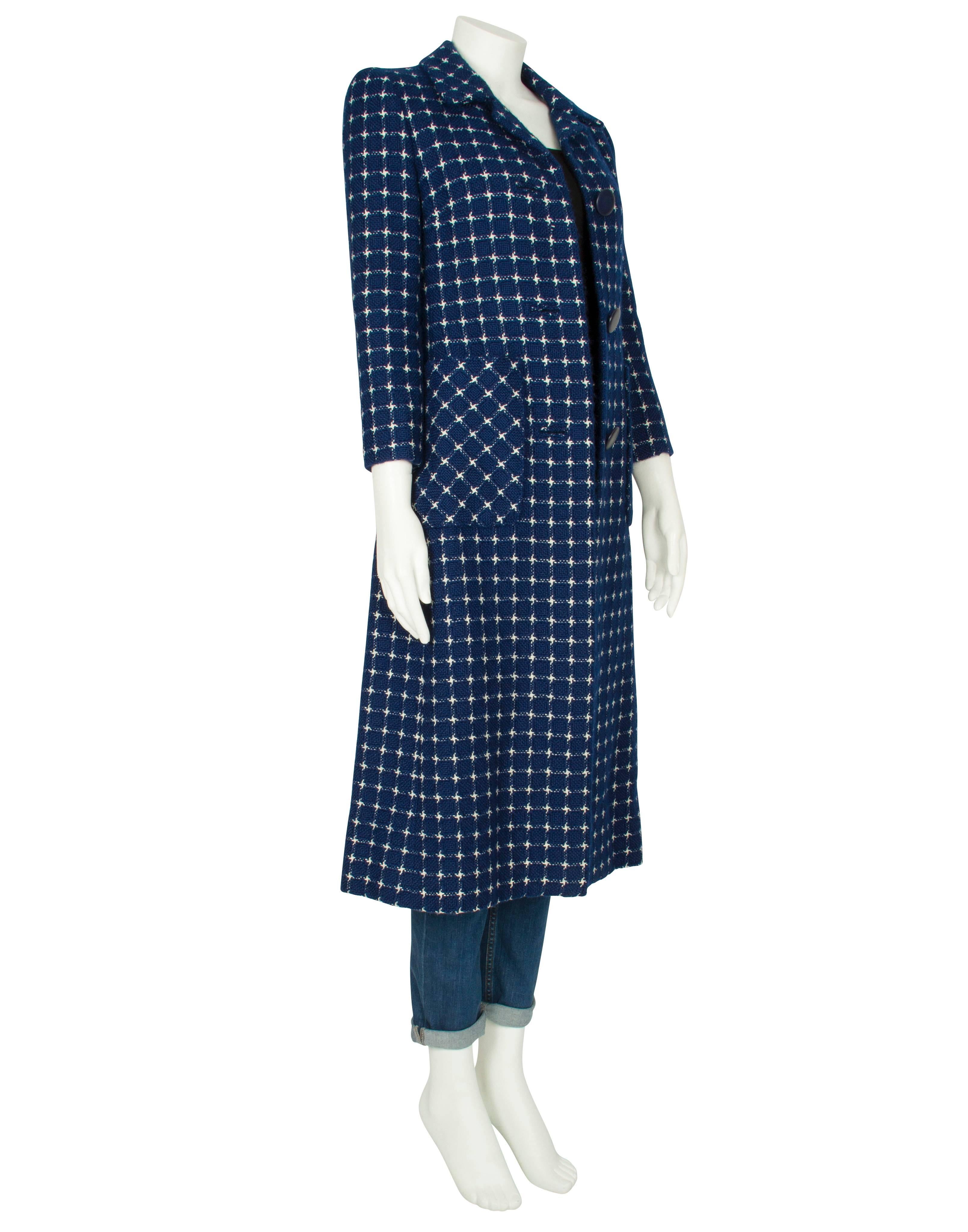 A short-sleeved ivory silk day dress by London society couturier Harald which features an all-over navy blue checked print and oversized navy blue buttons. The soft, lightweight dress is straight cut to the waist and features a round neckline with a