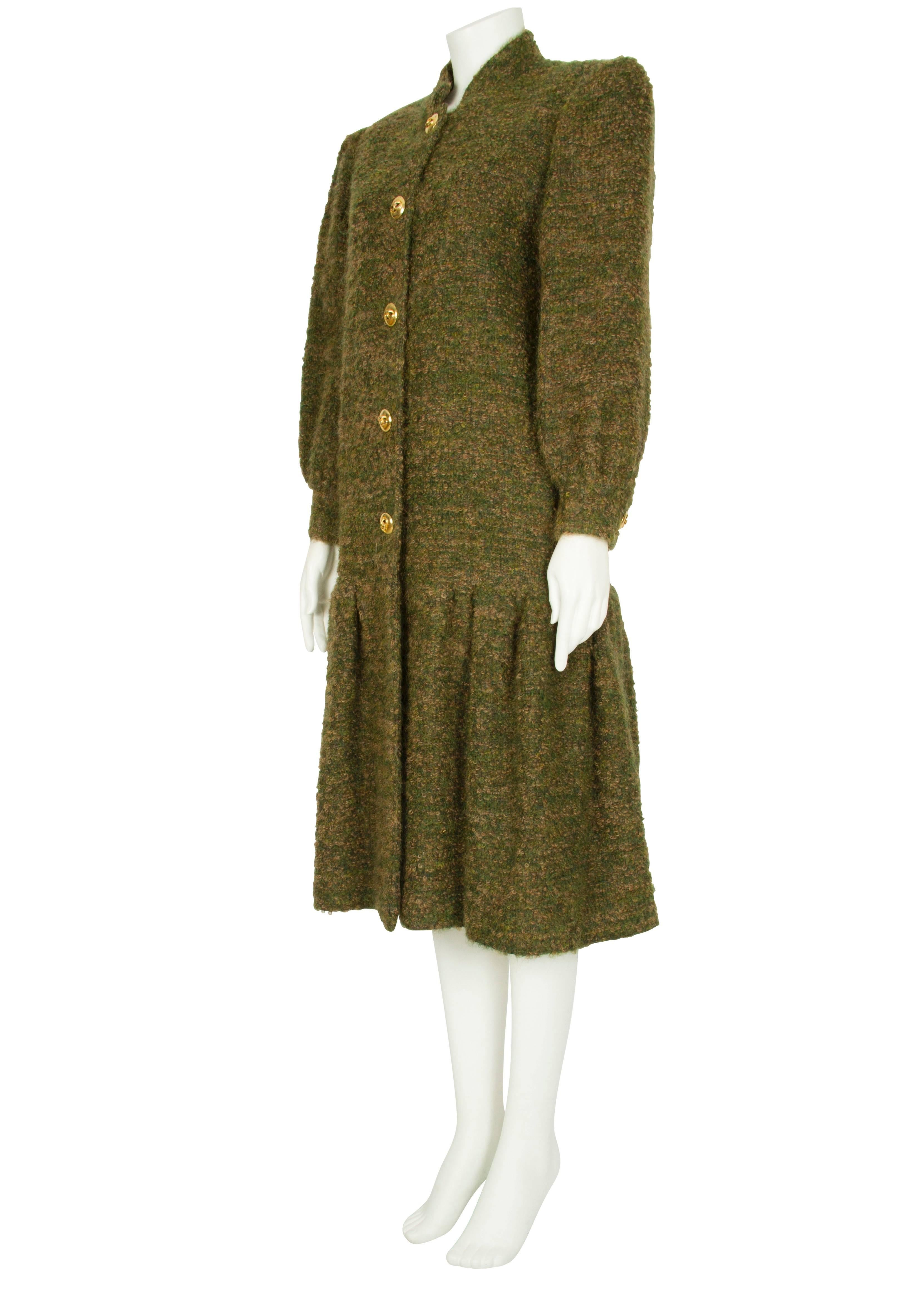 An elegant olive green and camel brown boucle wool coat by London society couturier Harald. The textured coat features a small high notched collar, gathered shoulders, three-quarter-length leg-o’-mutton sleeves with fitted cuffs and a light brown
