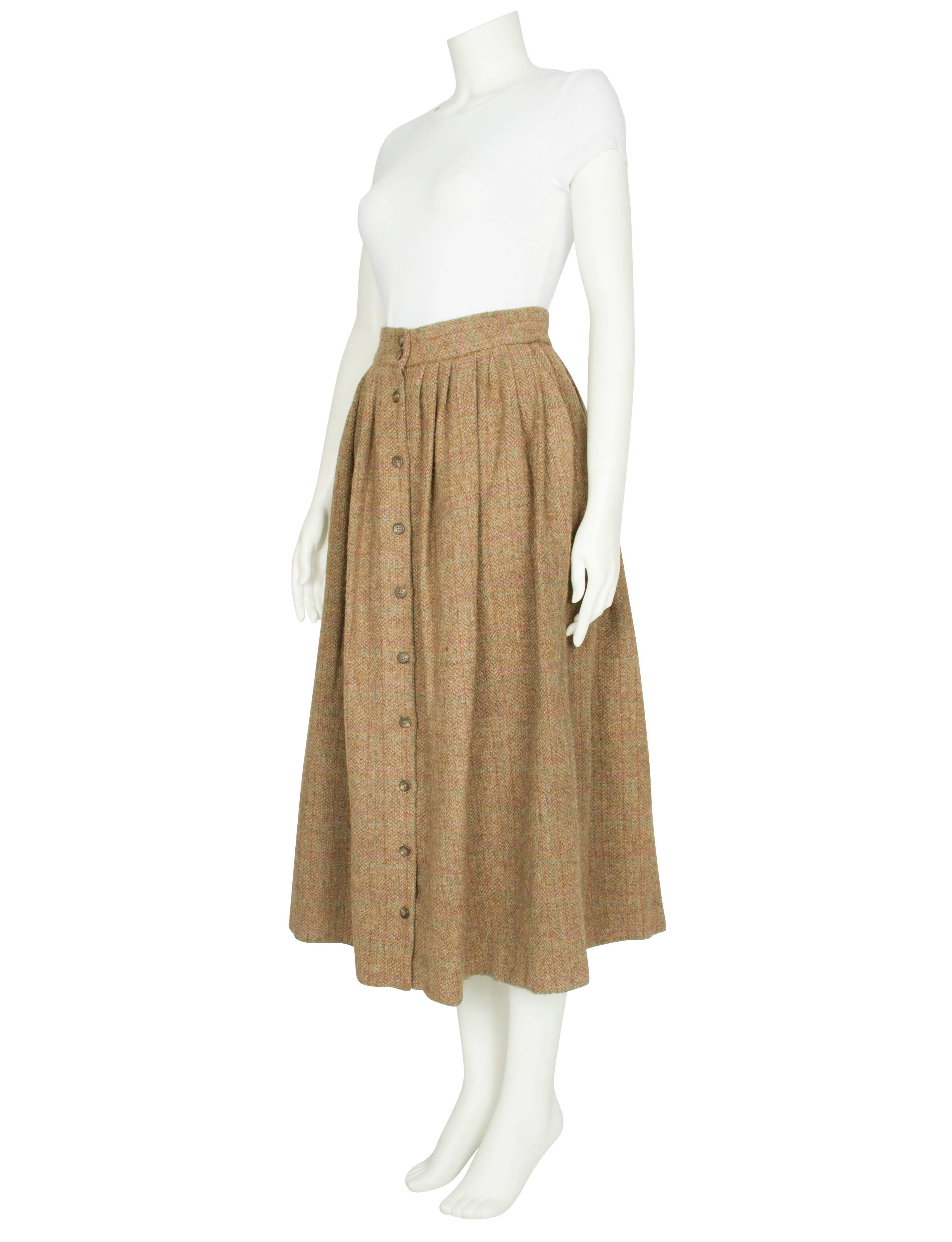 A late 1970s/early 1980s Polo Ralph Lauren pale brown tweed skirt with a faint purple and green check pattern. The heavy, textured full-length skirt features a fitted high waist, a softly pleated flared shape and an ochre silk lining. The skirt