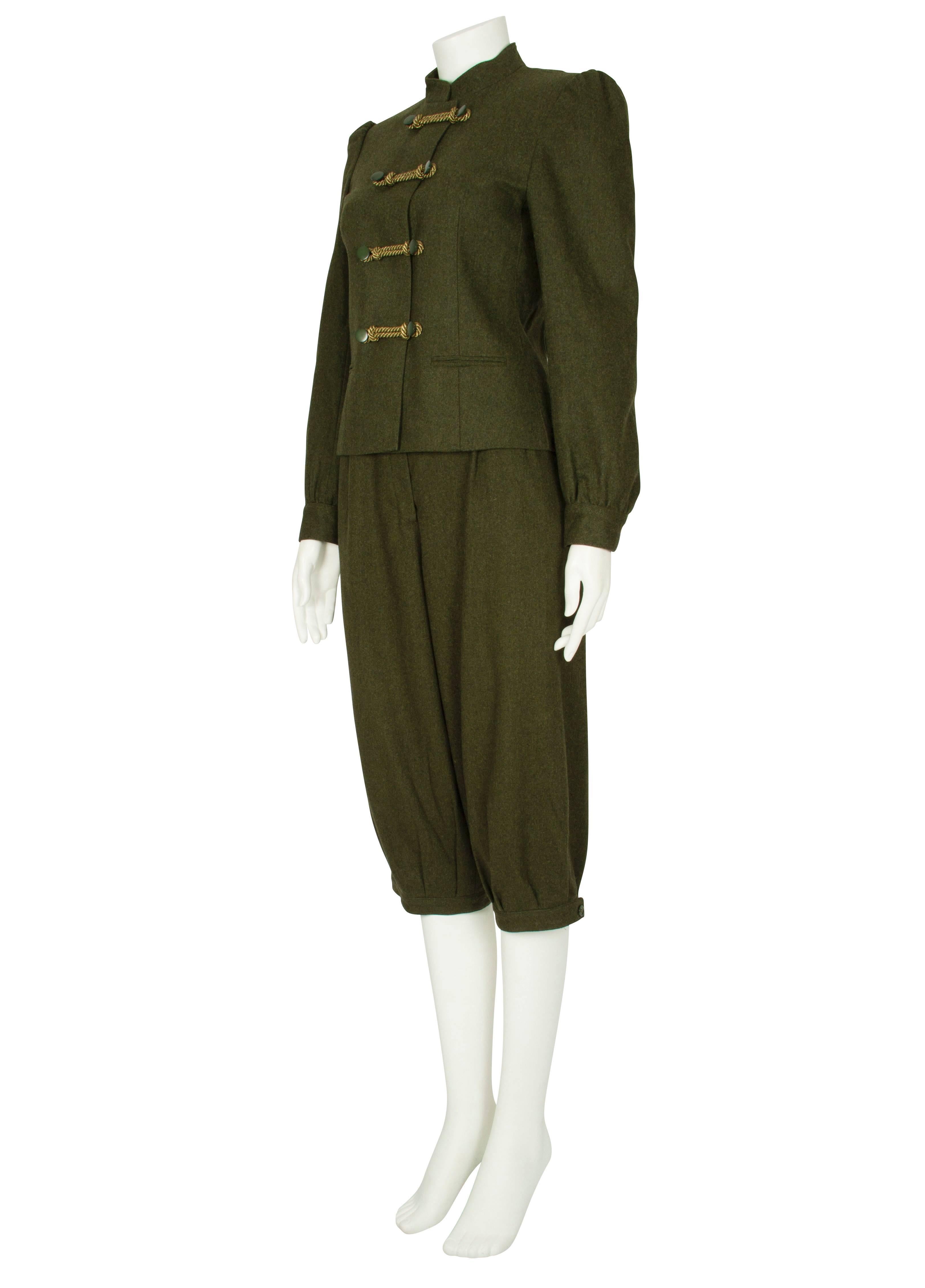 This unique moss green wool hunting ensemble features a cropped waist length fitted jacket with a stand up band collar and two side slit pockets. Fully lined in green viscose, the jacket has beautiful thick golden rope toggles that provide a