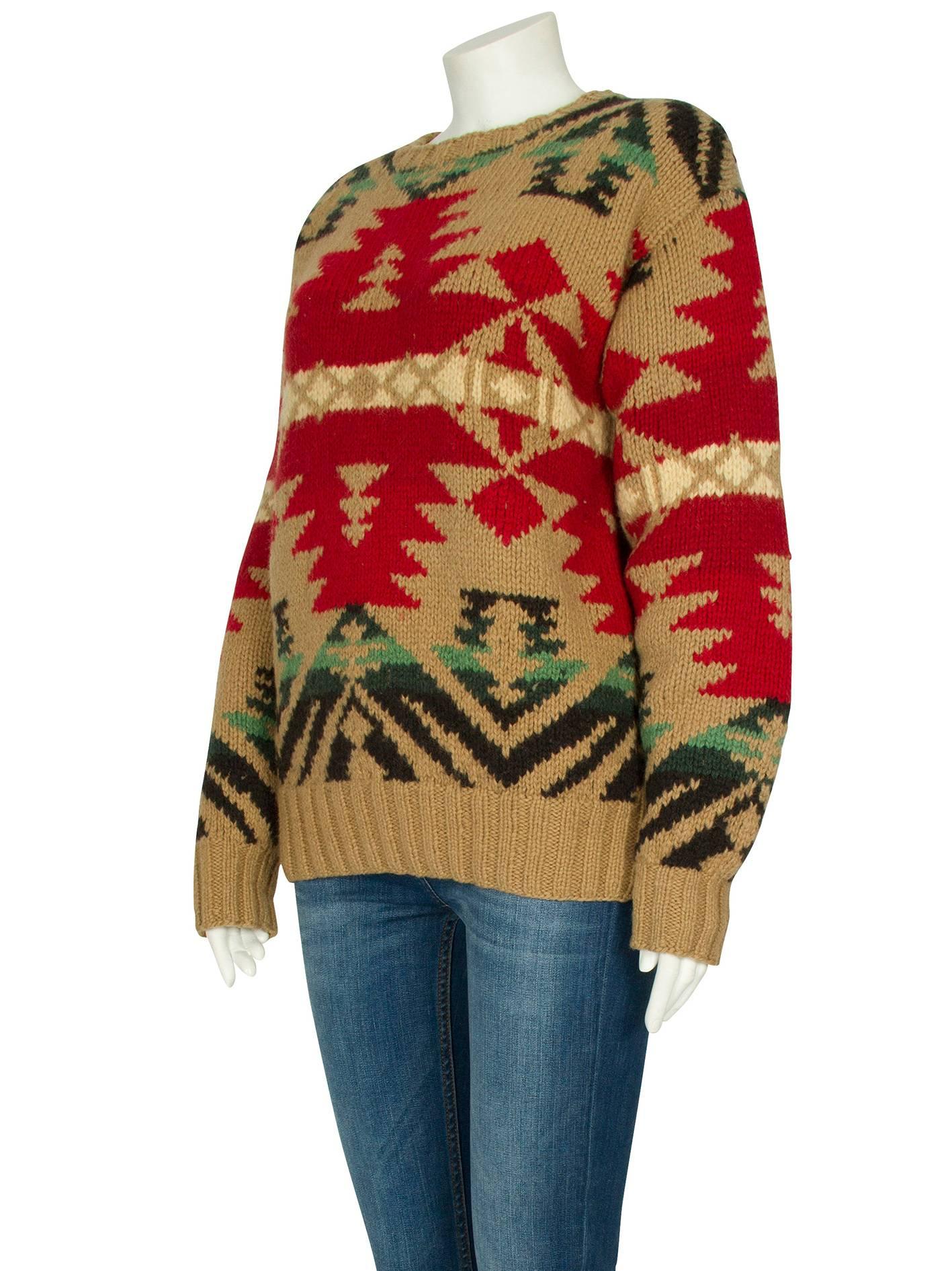 A Ralph Lauren beige wool jumper with a red, green and black Aztec pattern from the label’s 1988 collection. The chunky knit long-sleeved jumper features a round neckline, a ribbed trim and fitted ribbed cuffs. The jumper has a boxy shape and