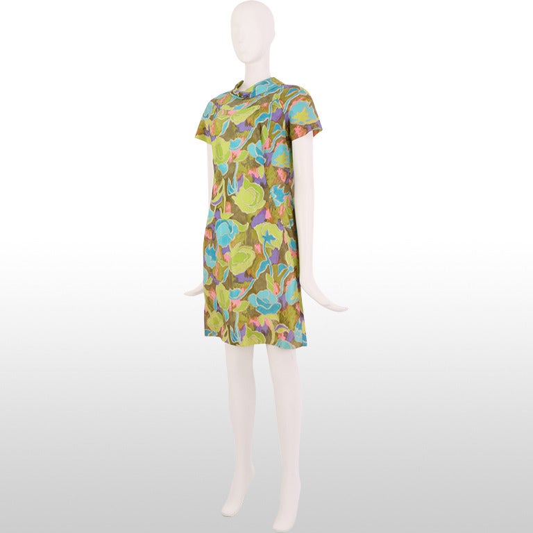 This colourful 1960's dress is made from fabric printed with an abstract large floral design in tones of hot pink, violet, lime green and blue to create a hand painted effect. This summer dress has an elegant cowl neckline and short capped sleeves.