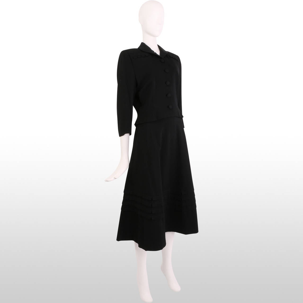 This beautiful black 1940's skirt suit is an original design by a Gathering Goddess favourite, Lilli Ann. It is a beautifully tailored piece made up of a cropped jacket with elegant quarter length sleeves and an A-line skirt which continues the pin