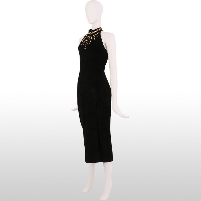 We think this 1980's black suede dress is a great way to rock a vintage look in a contemporary way! It is made from supple black suede which is embellished at the neckline and bust with metallic gold studs. The high neckline is fastens with a snap