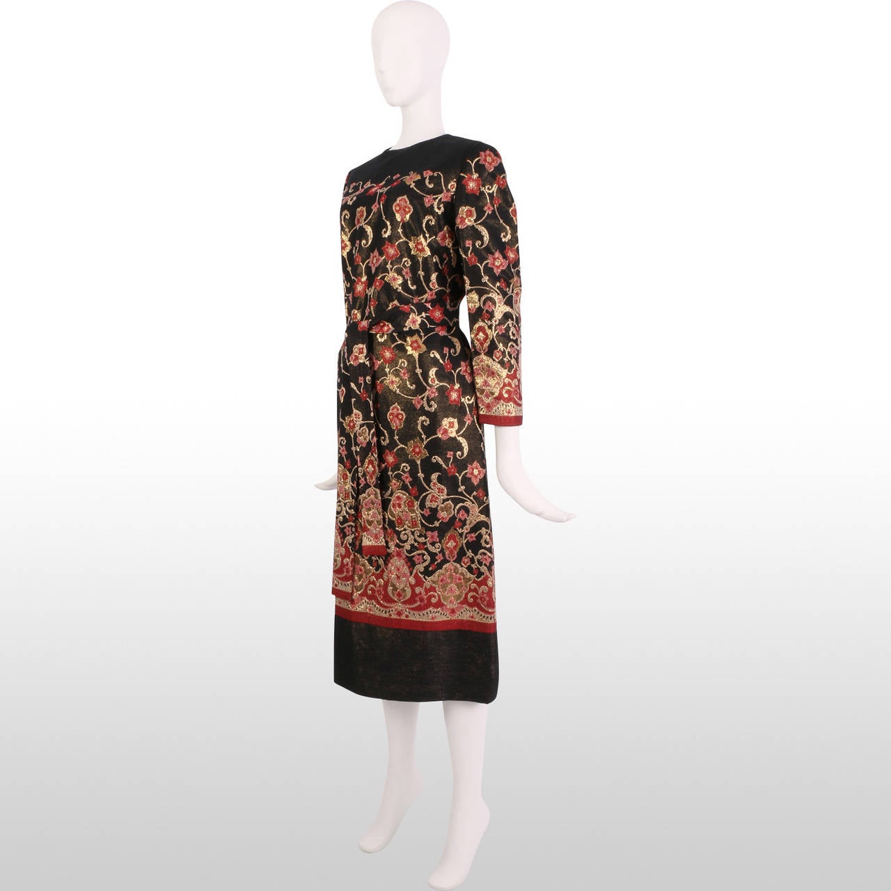 This immaculate 1960's Adele Simpson dress is beautifully made from a black, deep red, magenta and gold floral brocade fabric shot with metallic gold throughout to create a luxurious shimmer. The elegant shift dress can be worn with or without the