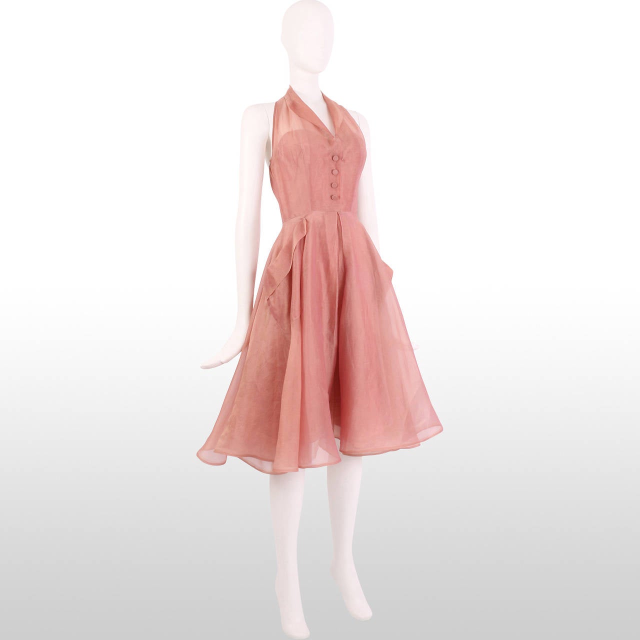 This lovely rose pink halter dress is perfect for any occasion! The lightweight organza fabric gives the dress a comfortable feel, while the nipped in waist and full skirt gives the classic silhouette of the 50's. The gorgeous rose pink hue makes