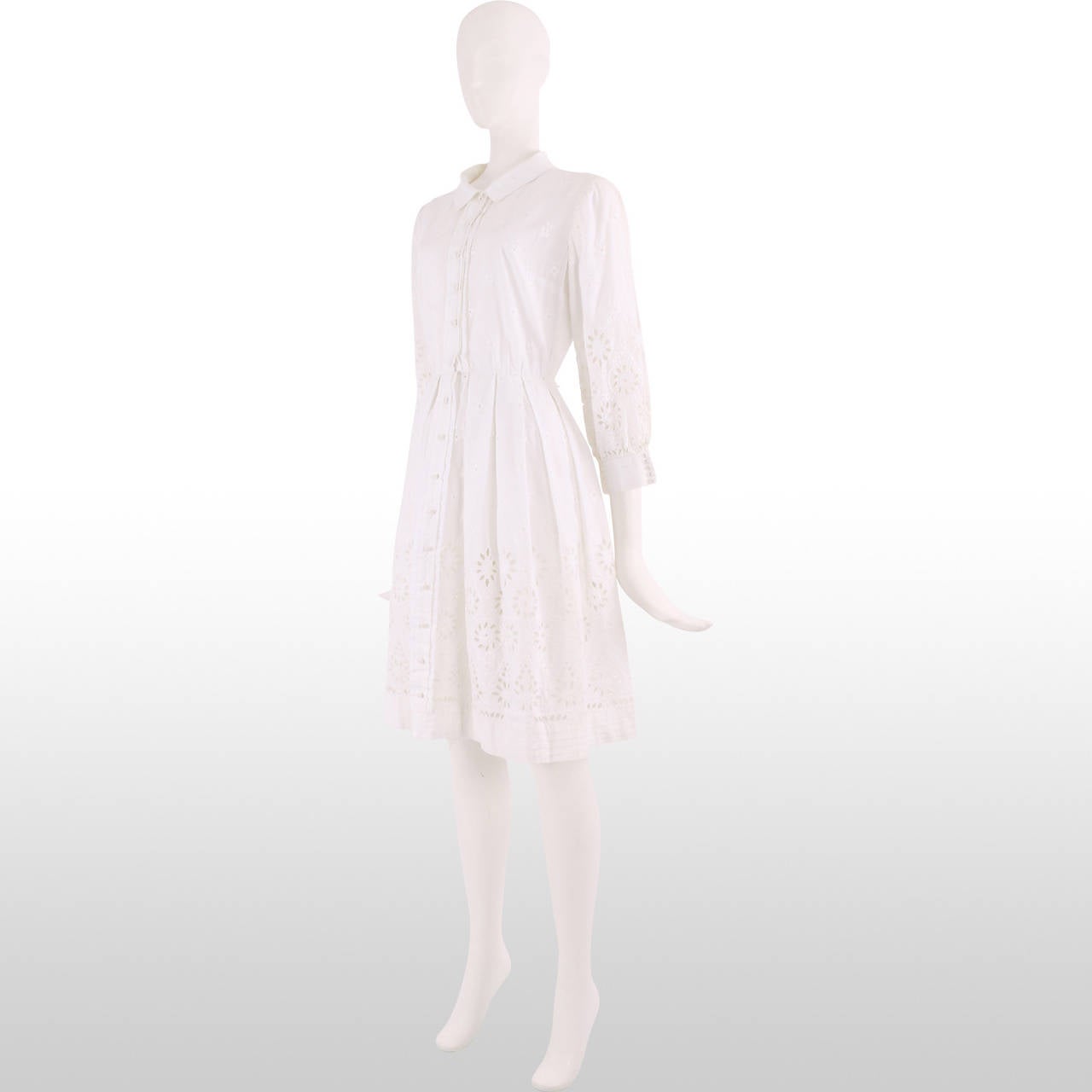 This 1950's summer dress is made from snow white cotton which has broderie anglaise detail throughout which becomes more extravagant on the sleeves and the hem of the dress. The hem and the cuffs have pleated detailing and the cuffs have a row of