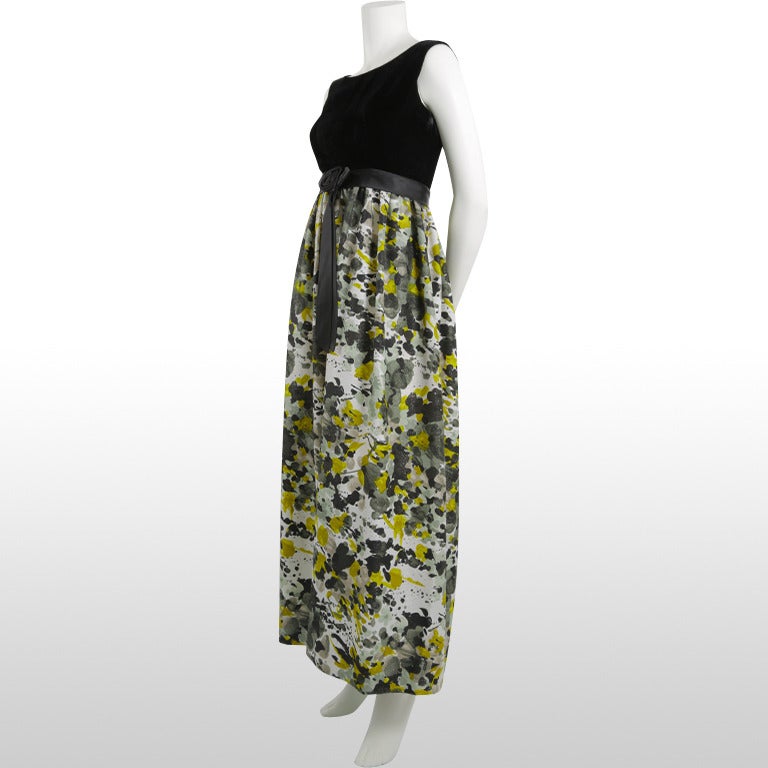 This stunning gown features a black cotton velvet sleeveless fitted bodice with a mustard yellow, olive, light and dark grey glittery abstract floral print skirt made from Lurex fabric. The statement skirt is slightly gathered from the black satin