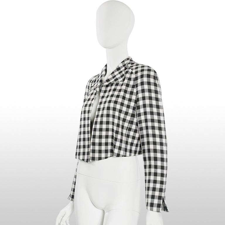 This 1980's jacket by Christian Dior is made from a checked woven silk fabric into a black and white check design. The rest of the jacket is simplistic, with a pointed collar, full length sleeves and cropped length. This jacket does not fasten but