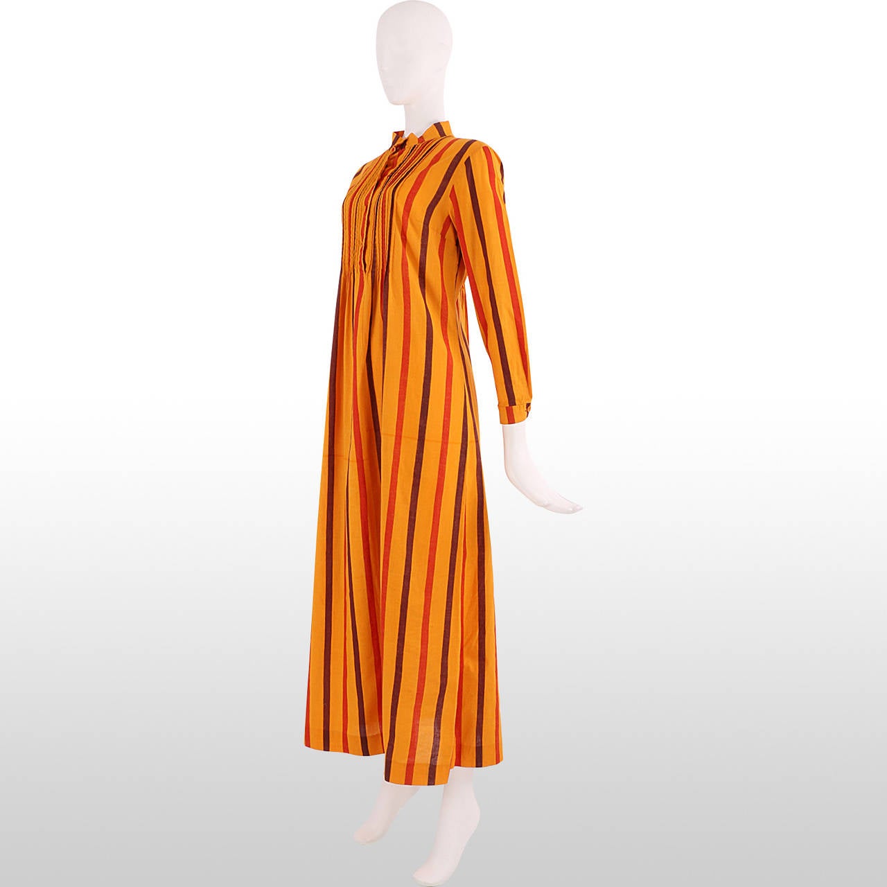 This 1970's piece by Marimekko is great for a summer festival or holiday wear. Made from striped printed cotton in oranges and brown it has a high standing collar and button down neckline. The bodice is has pleated panelling at the front and back.