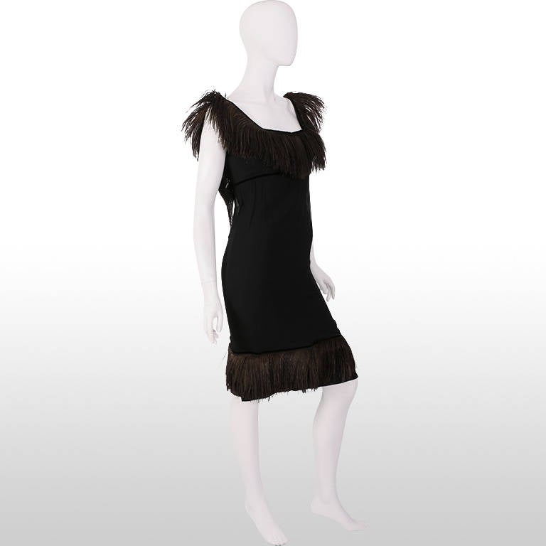 This stunning 1960's cocktail dress will make a statement at any evening event with its distinctive and luxurious velvet ostrich trim decorating the neck line and hem. It's chiffon overlay adds another layer of sophistication to this fully lined