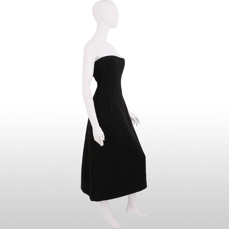 This gorgeous dress is a Donna Karan design from the 1990's. It is made from luxurious black wool and oozes sophistication with its simple, sleek, shape. This is a strapless dress with a simple invisible pouch pocket at the front of the dress. The