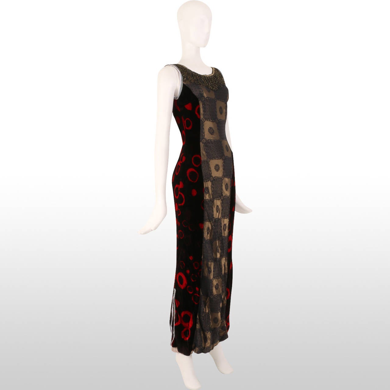 This original Voyage dress holds a variety of textures with the use of black and crimson velvet for a majority of the dress with a contrasting gold and steel grey embroidery metallic panel down the centre of the garment. The luxurious feel of the