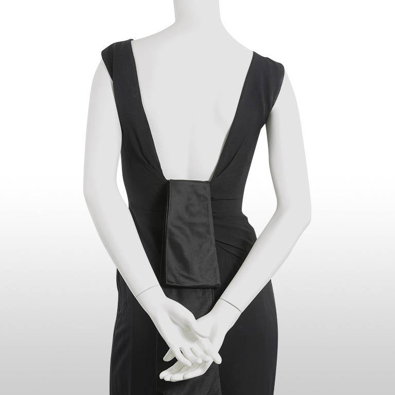 This gorgeous 1960's Estevez is the perfect LBD. It is an elegantly simplistic shape, what makes this dress special is the plunging low back and over-sized black satin bow which sits at the back. Made from black silk crepe this dress drapes