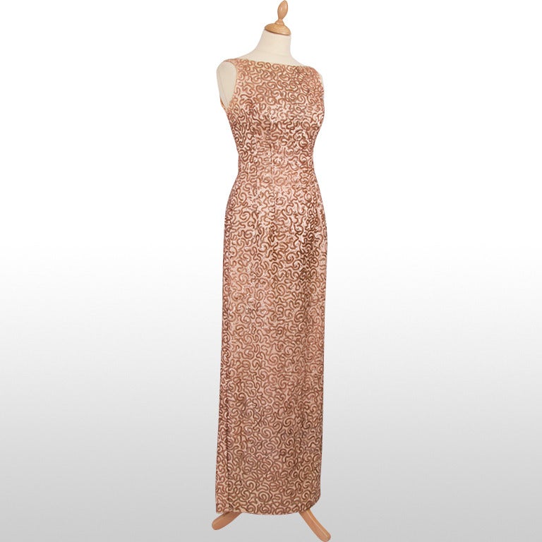 The beautiful 1950's fishtail gown has an ornate sequin embellishment in a soft pink, throughout the garment. It has a deep v-neck back.