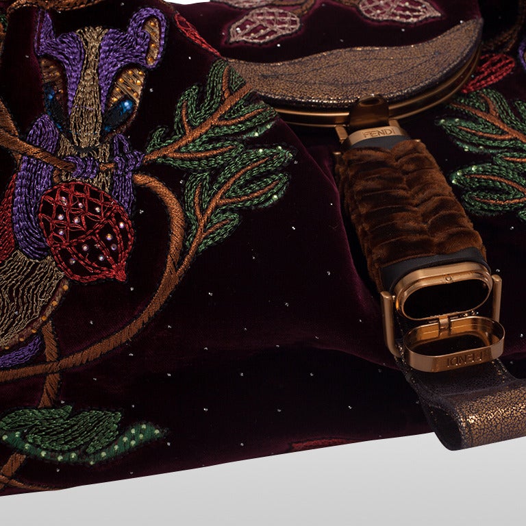 It is rare to come across this particular Fendi Squirrel Spy bag. It was first seen in 2005/2006. The rich burgundy velvet is festooned with vibrantly coloured metallic threads and glass beading shaped like squirrels and acorns which is an early