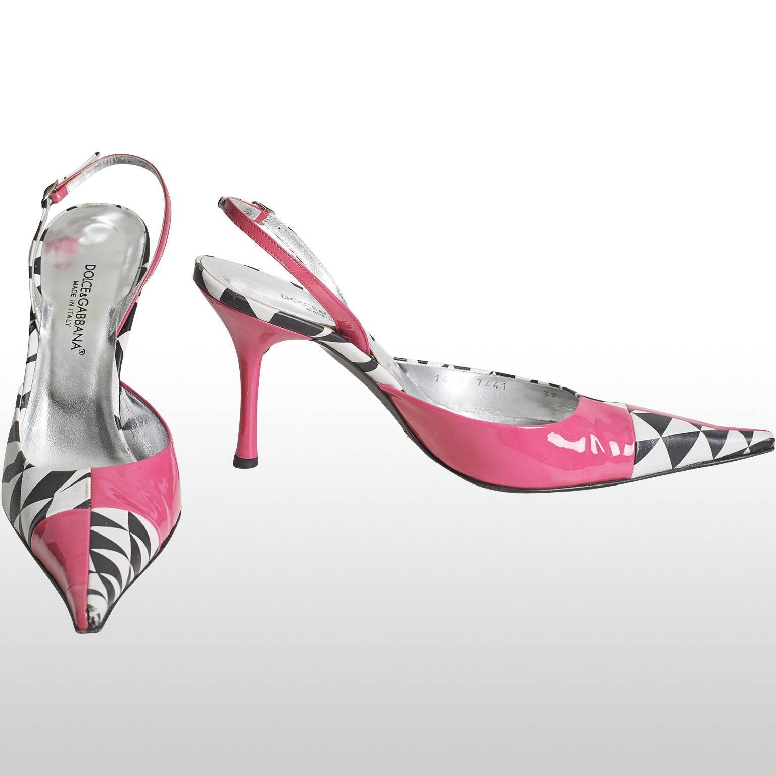 These are fun sandal shoes by Dolce and Gabbana. The shoe has a pointy toe with a check pink and monochrome pattern. The heel of the foot is secured with a thin strap and a small metallic buckle. The insole of the shoe comes in a shiny metallic