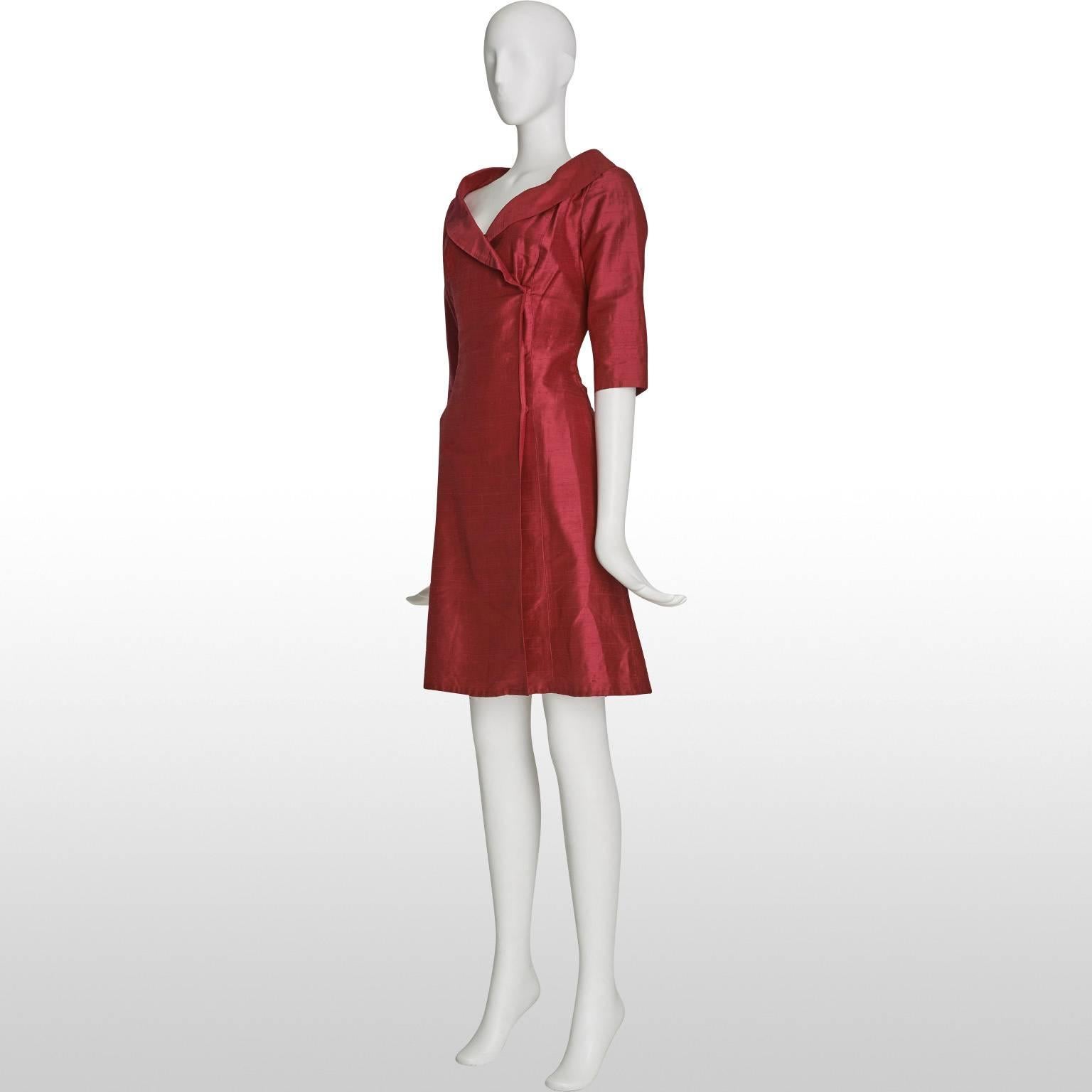 This is a elegant and sophisticated wrap dress from the 60's. The fabric is made out of a claret raw silk. The dress has a wide shawl collar which beautifully displays the neckline of the wearer. The dress remains in excellent condition. 